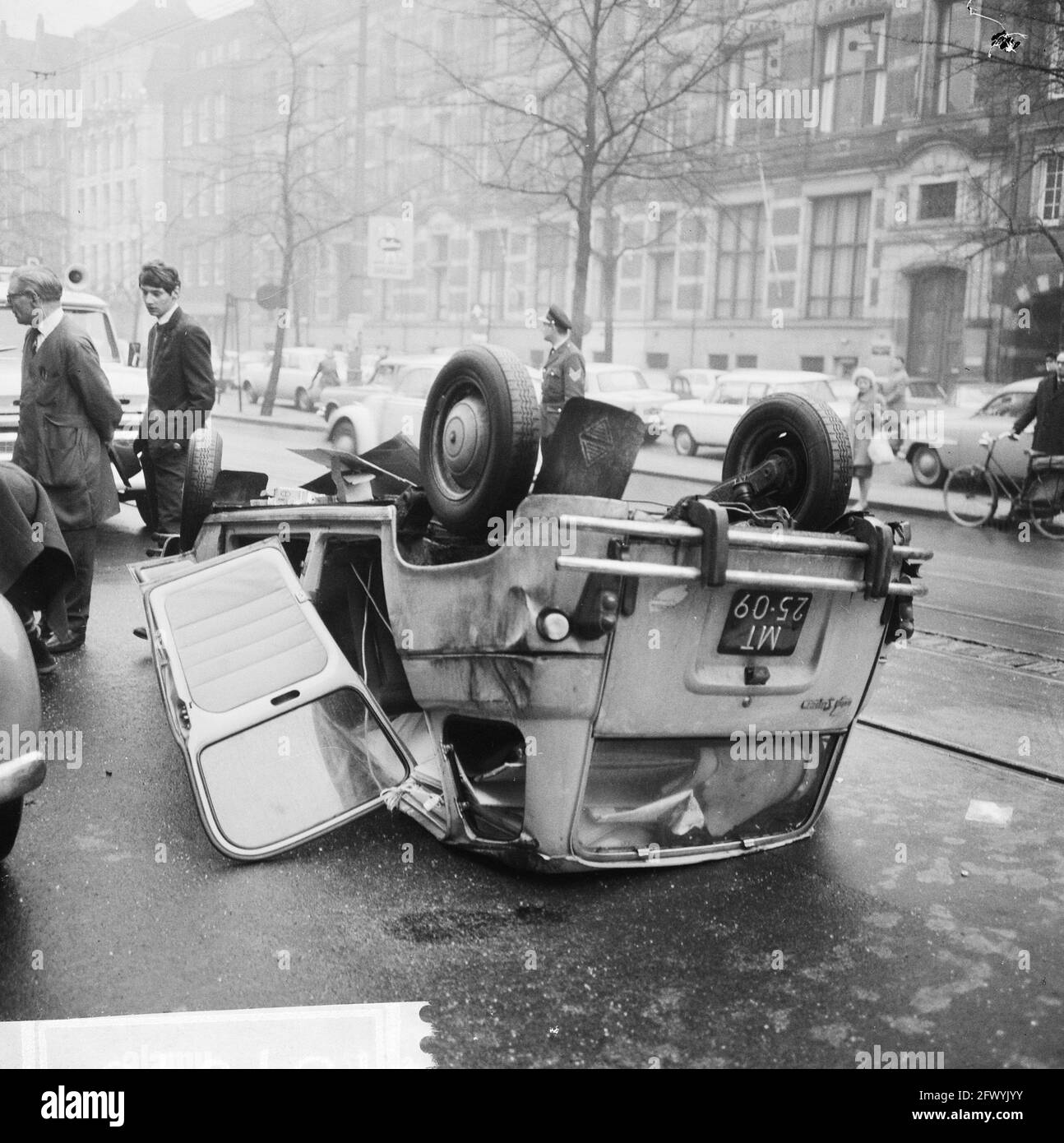 Car upside down on Rokin, exclusive Parool, January 22, 1966, Autos, The Netherlands, 20th century press agency photo, news to remember, documentary, historic photography 1945-1990, visual stories, human history of the Twentieth Century, capturing moments in time Stock Photo
