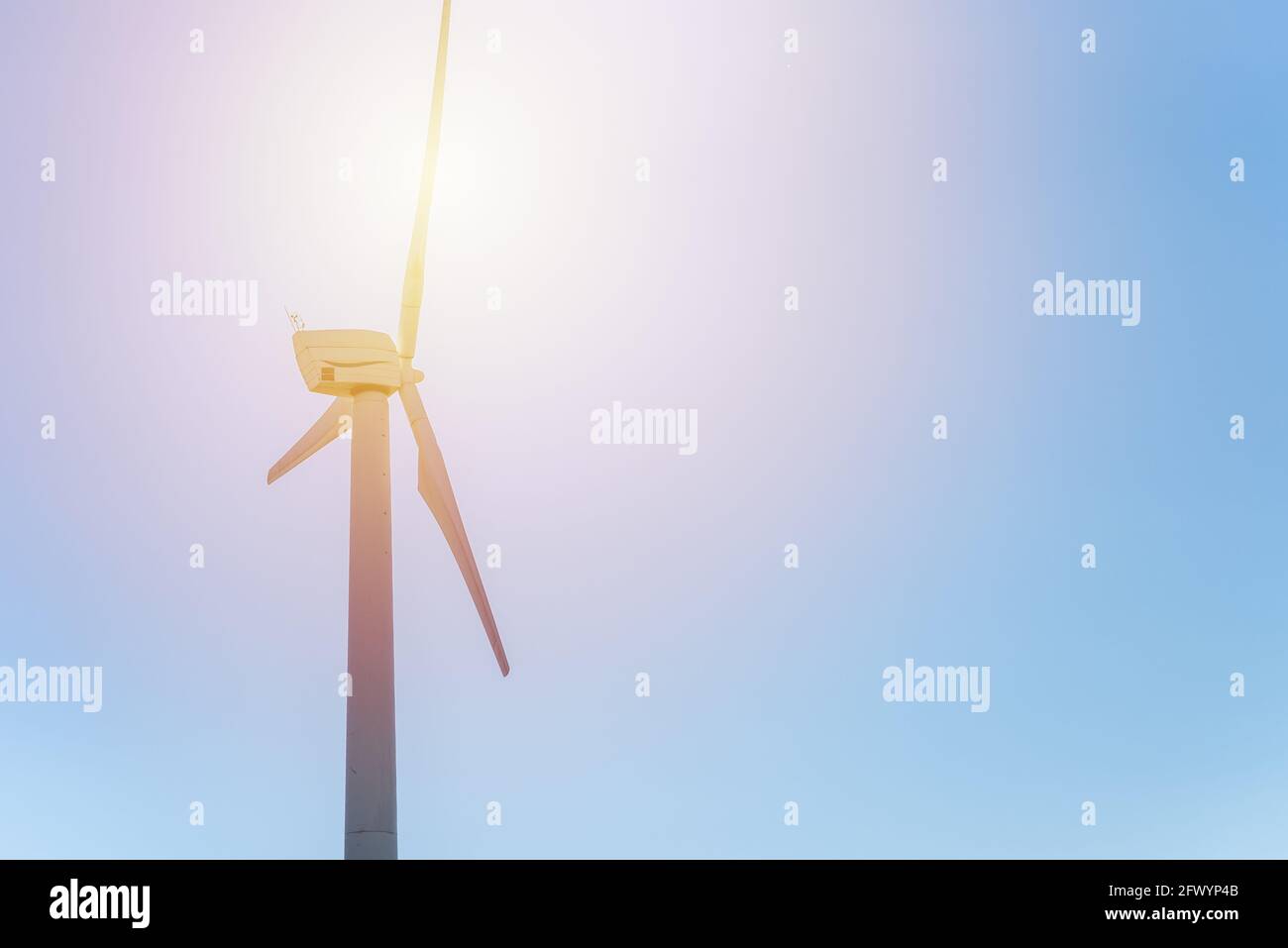 Wind power,one wind turbine blue skyand sun.wind power concept with ...