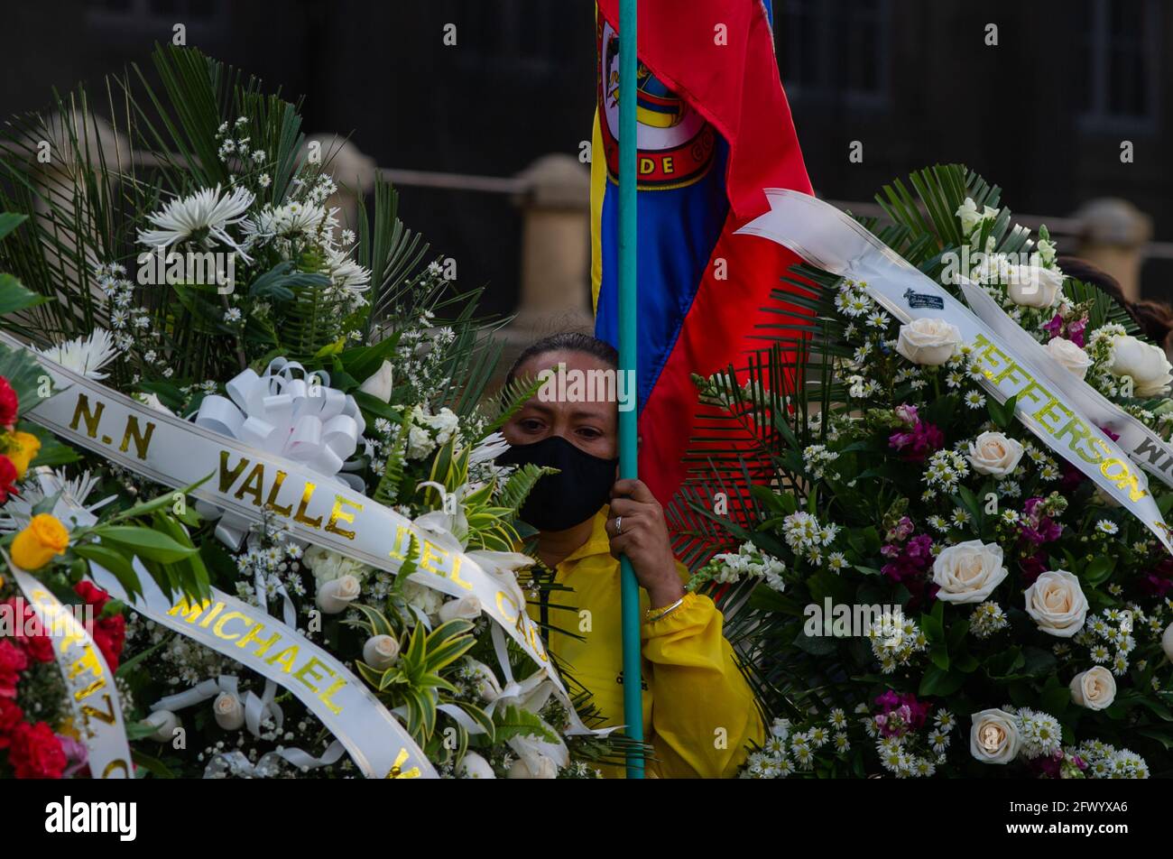 Bogota, Colombia. 24th May, 2021. A demonstrator with a Colombian flag stands on the side of several funeral wreaths as citizens and demonstrators support the congress sesion in which Minister of Defence Diego Molano was put into Motion of No Confidence (Motion Censor) after the cases of police brutality during the first month of protests in Colombia that now reach at least 45 dead in police and abuse of authority cases. In Bogota, Colombia on May 24, 2021. Credit: Long Visual Press/Alamy Live News Stock Photo