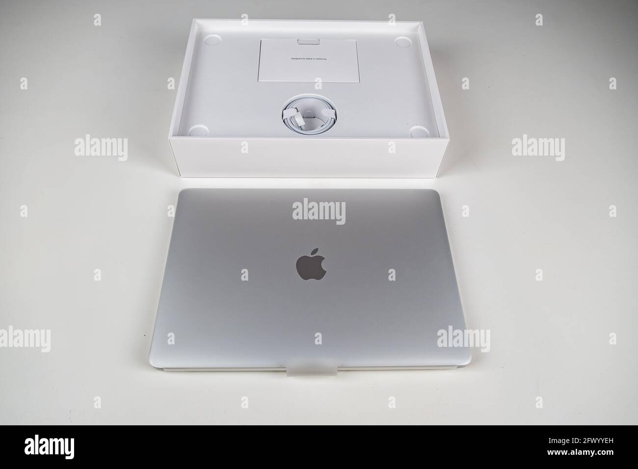 Unboxing a silver macbook air on a white table. Apple laptop Stock Photo