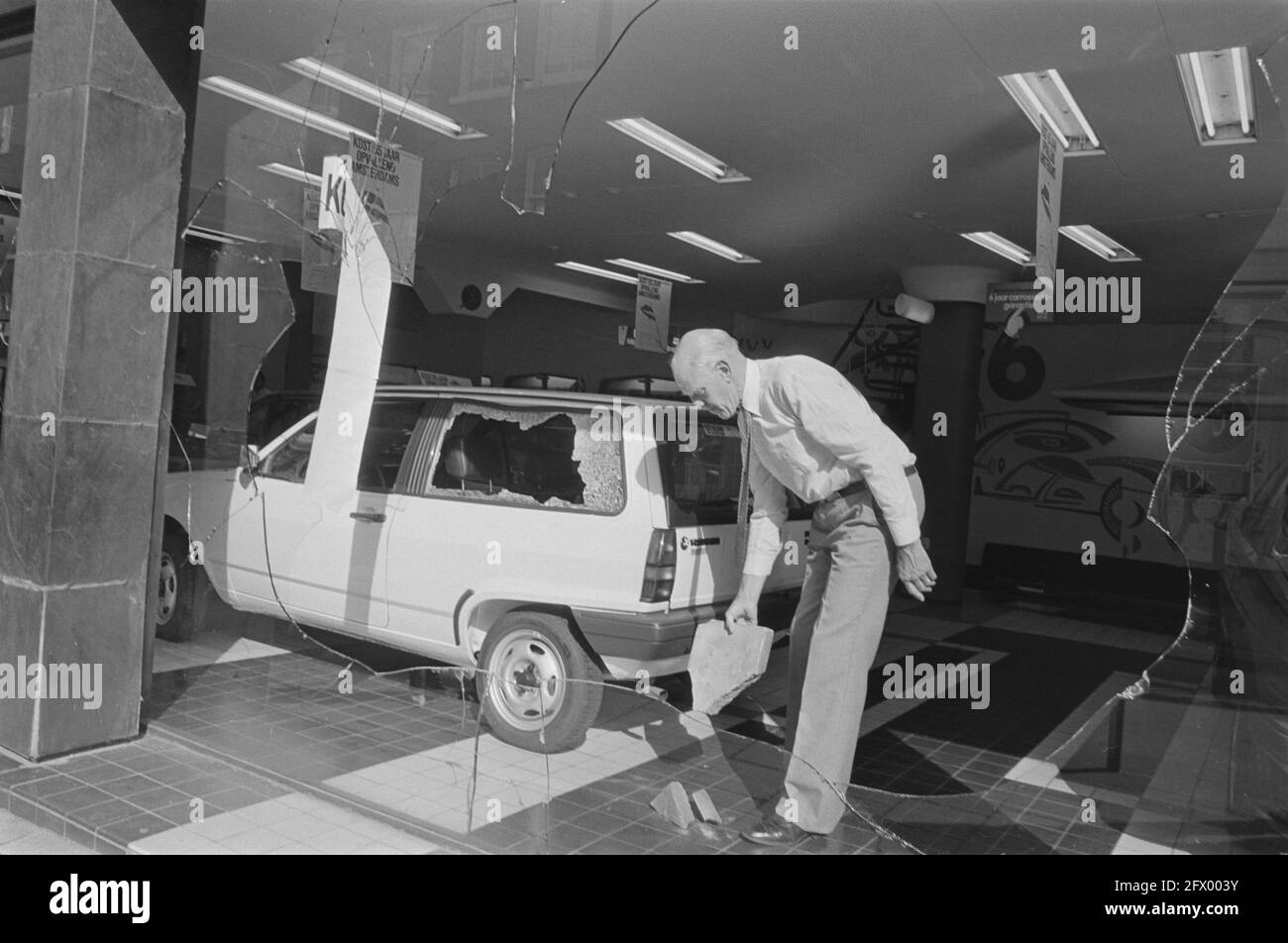 Windows of Volkswagen dealer smashed in protest against VW investments in South Africa; owner Kost with brick at broken window, 12 August 1985, WINDOWS, cars, bricks, protests, The Netherlands, 20th century press agency photo, news to remember, documentary, historic photography 1945-1990, visual stories, human history of the Twentieth Century, capturing moments in time Stock Photo
