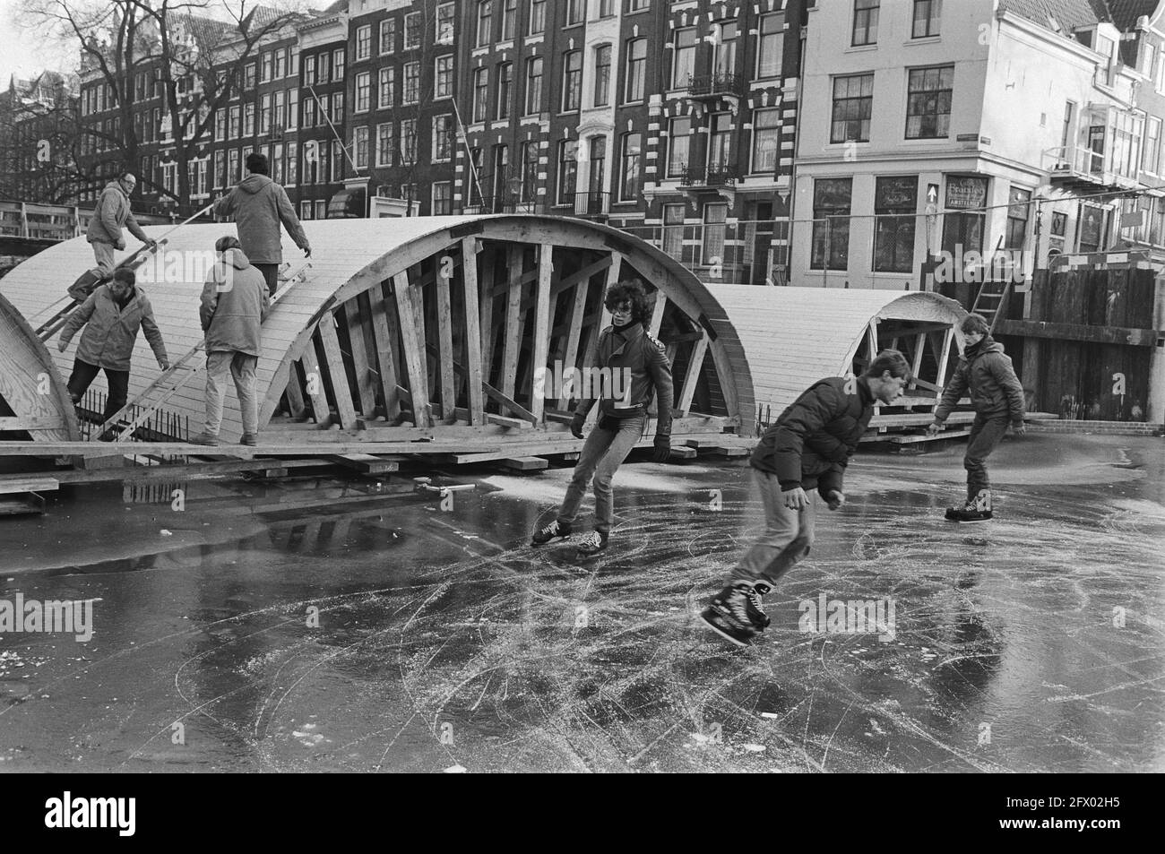 Skaters on canal intersection Keizersgracht/Leliegracht where an Amsterdam high bridge is being restored, 15 January 1982, GRACKS, skaters, The Netherlands, 20th century press agency photo, news to remember, documentary, historic photography 1945-1990, visual stories, human history of the Twentieth Century, capturing moments in time Stock Photo