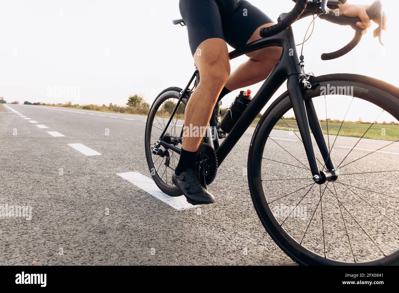 Professional cyclist riding bike on paved road Stock Photo