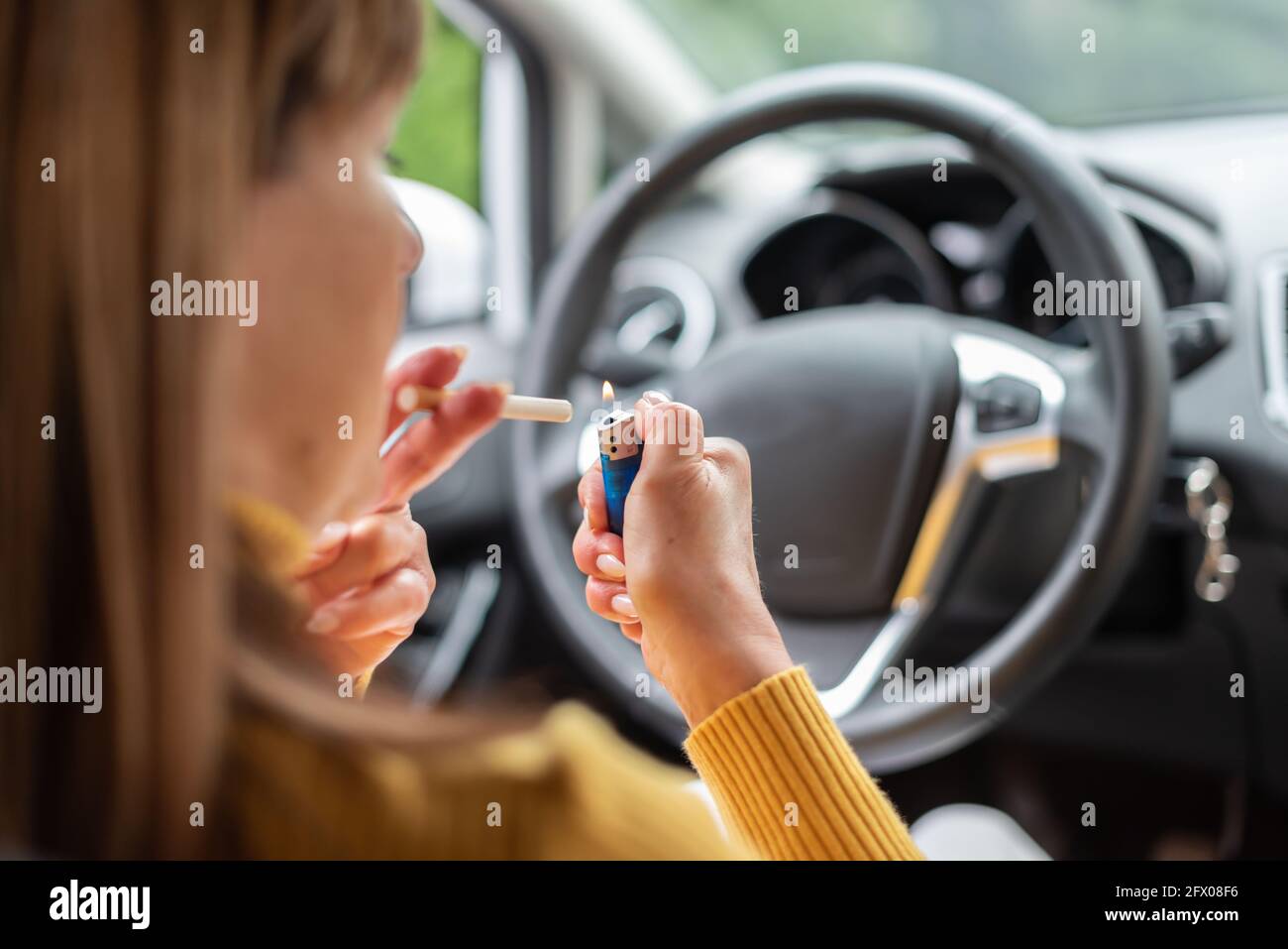 Woman lighting a cigarette in car Stock Photo Alamy