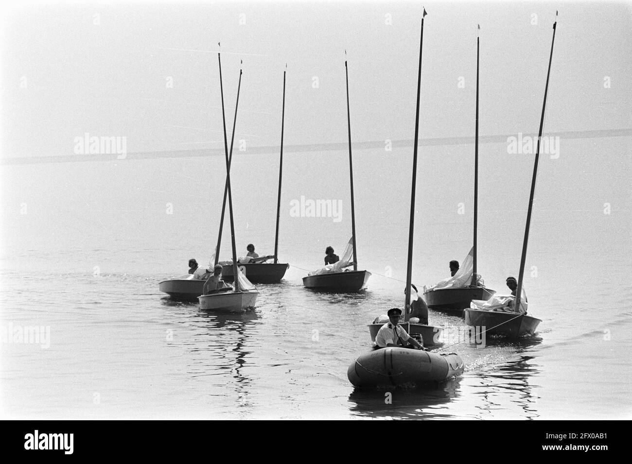 European Championships OK-jollies on the IJsselmeer; boats are towed back because of too little wind, July 31, 1970, CHAMPIONSHIPS, boats, The Netherlands, 20th century press agency photo, news to remember, documentary, historic photography 1945-1990, visual stories, human history of the Twentieth Century, capturing moments in time Stock Photo