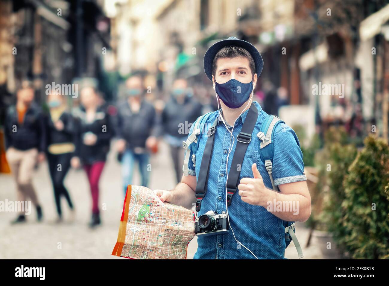 Happy hipster tourist with face mask walking on city street during summer vacation Stock Photo