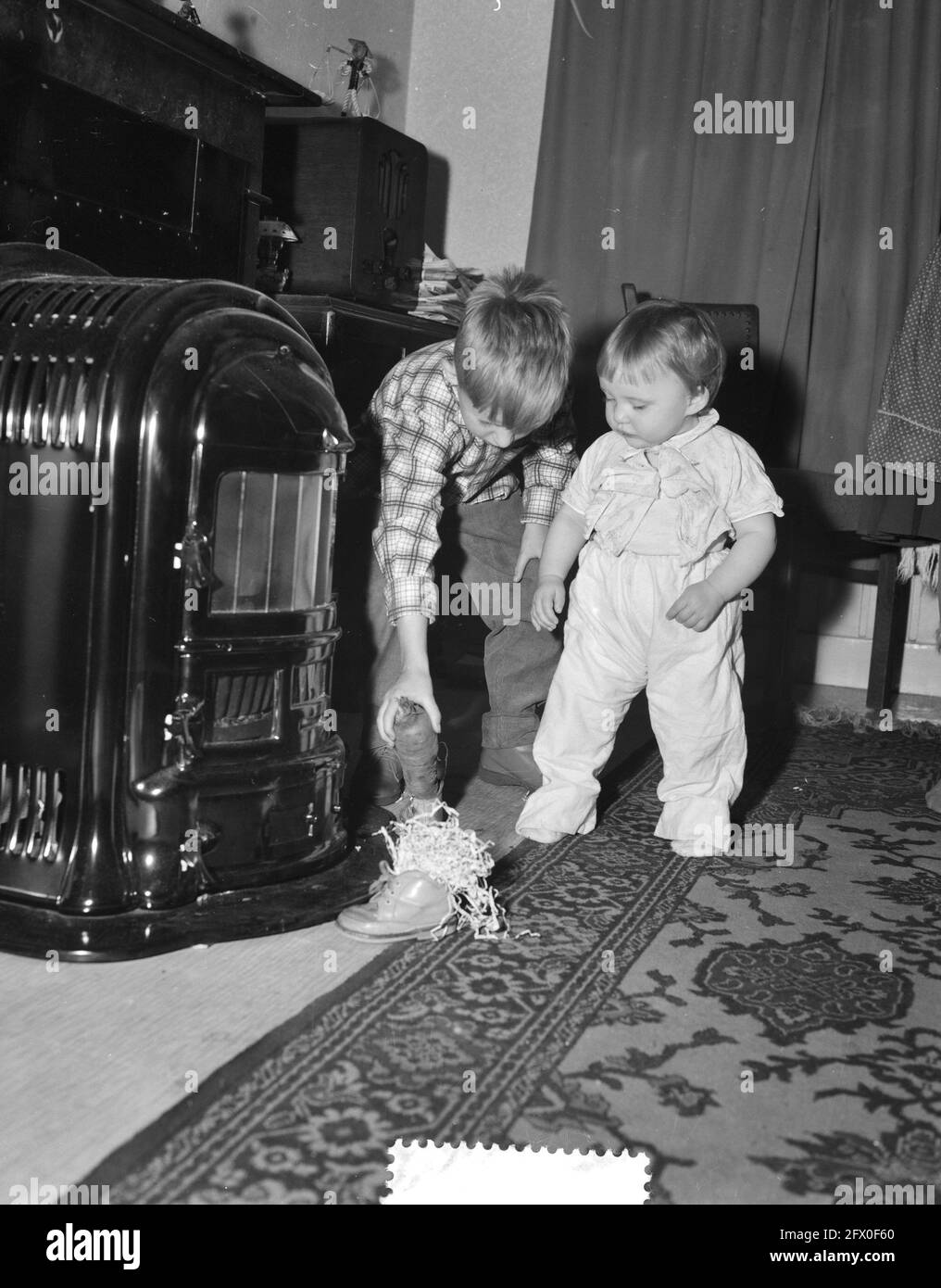 Sinterklaas putting shoe at stove, December 1, 1959, SINTERKLAAS