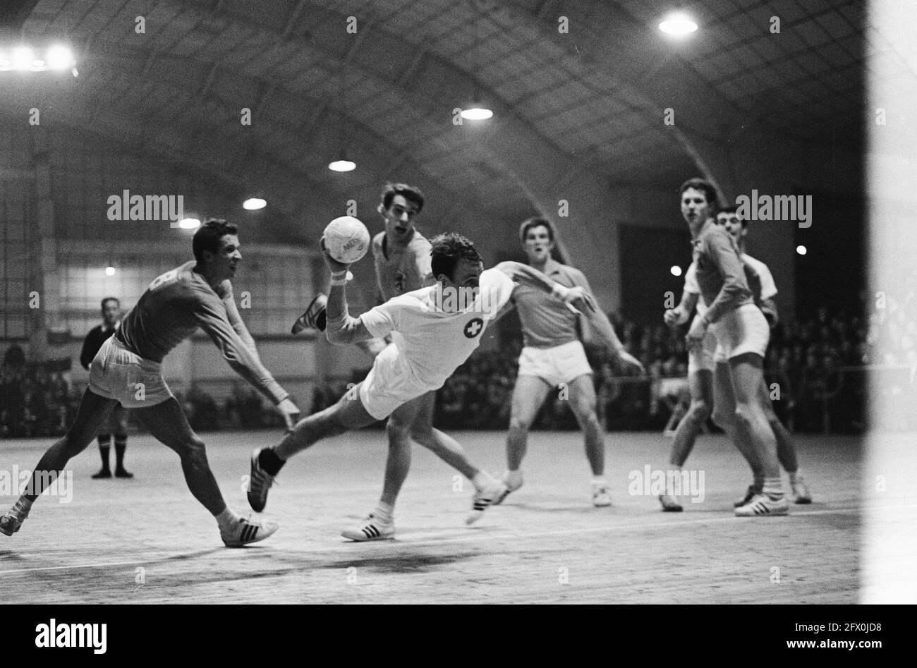 Indoor handball Netherlands against Switzerland 8-14, Bruno Schmidt for Switzerland scores here, February 26, 1966, Indoor handball, The Netherlands, 20th century press agency photo, news to remember, documentary, historic photography 1945-1990, visual stories, human history of the Twentieth Century, capturing moments in time Stock Photo