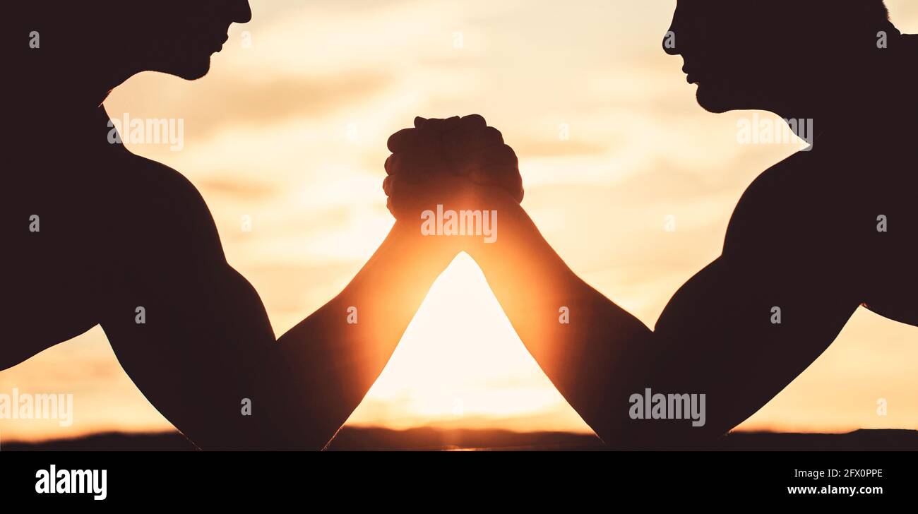 Men measuring forces, arms. Two men arm wrestling. Rivalry, vs