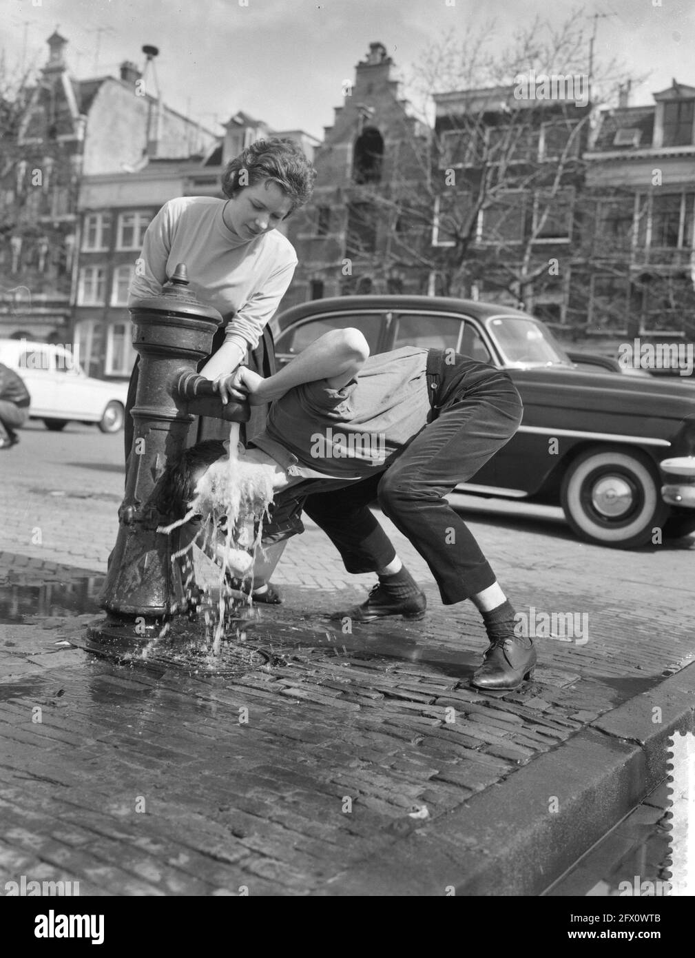 Sunbathing in Amsterdam. Dave Brinkman under pump, March 17, 1961, The