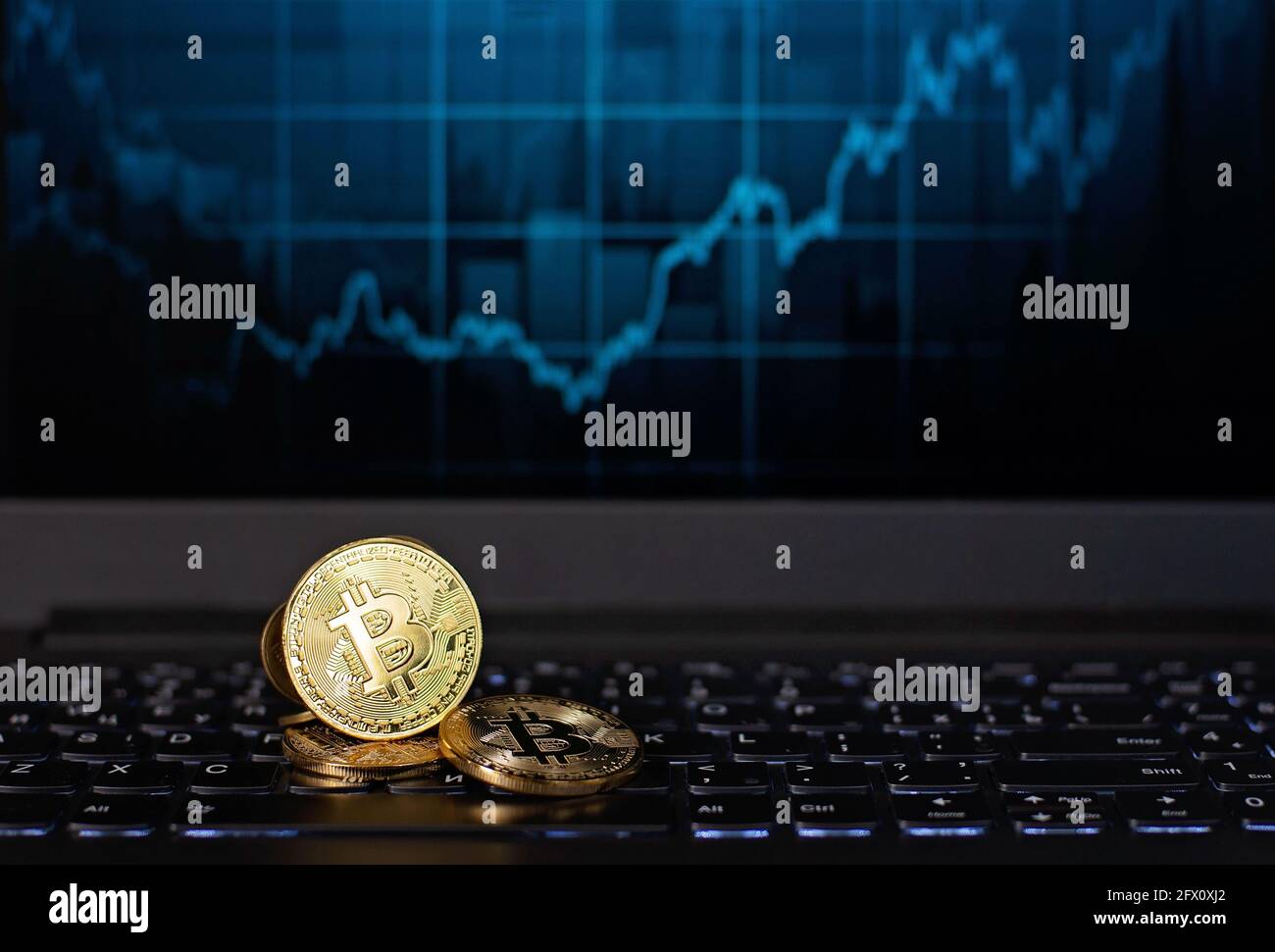 Bitcoin coins on a keyboard against the background of a defocused ...