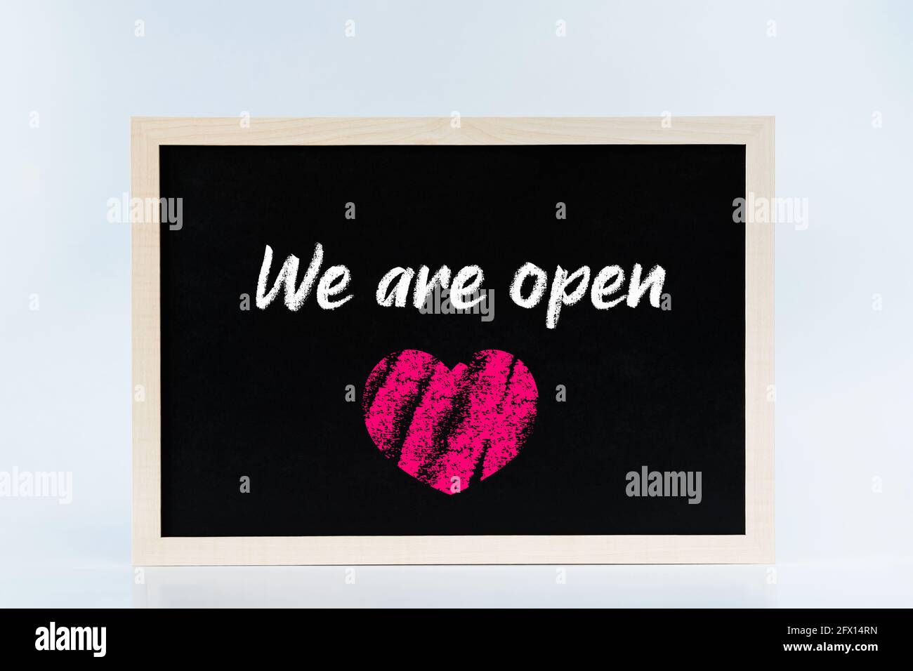We are open chalkboard sign with a chalk heart. Post lockdown reopening concept Stock Photo