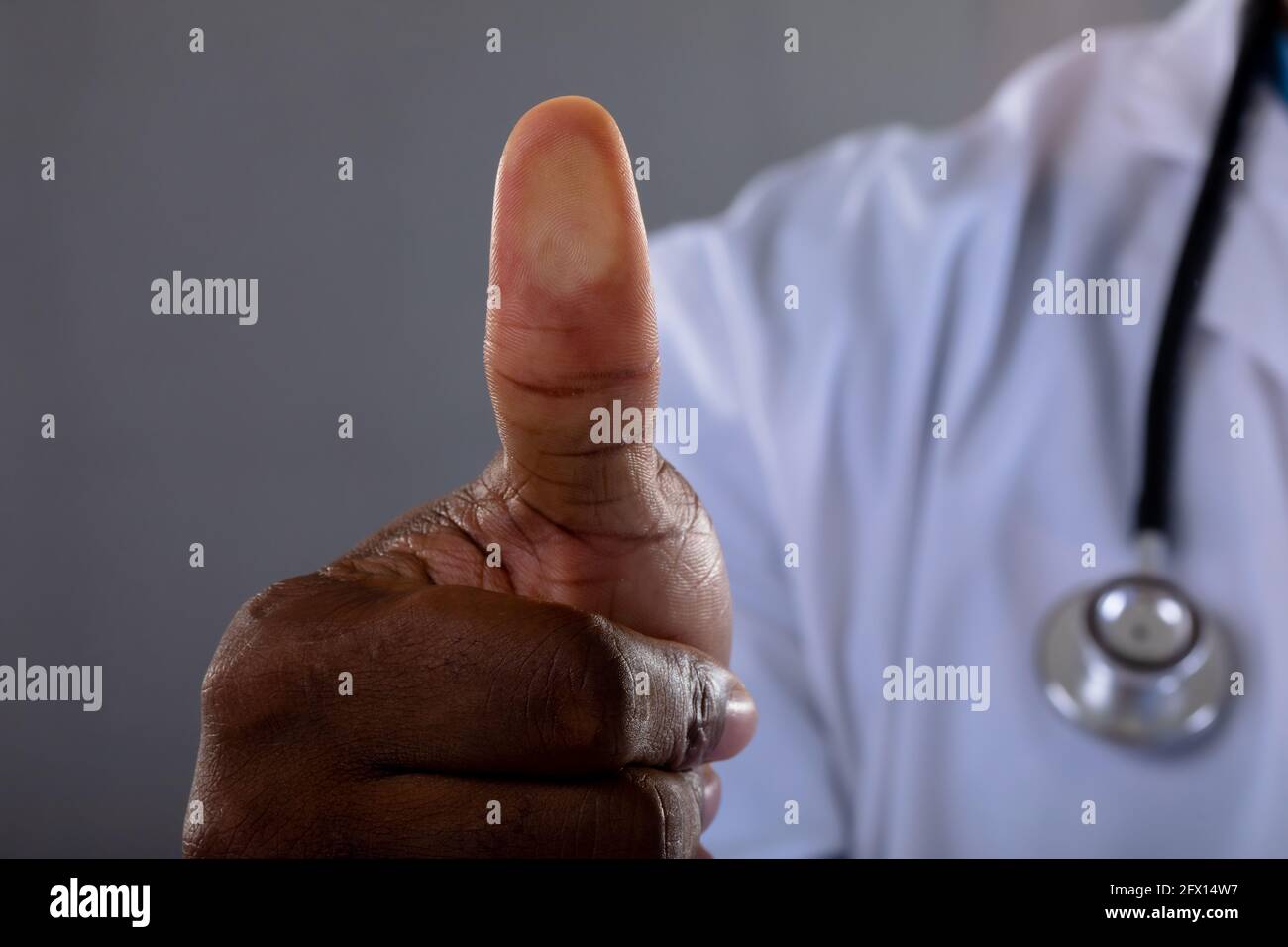 Mid section of african american male doctor scanning thumb against ...