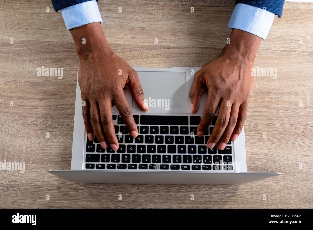 Over head view of businessman using laptop on wooden table Stock Photo