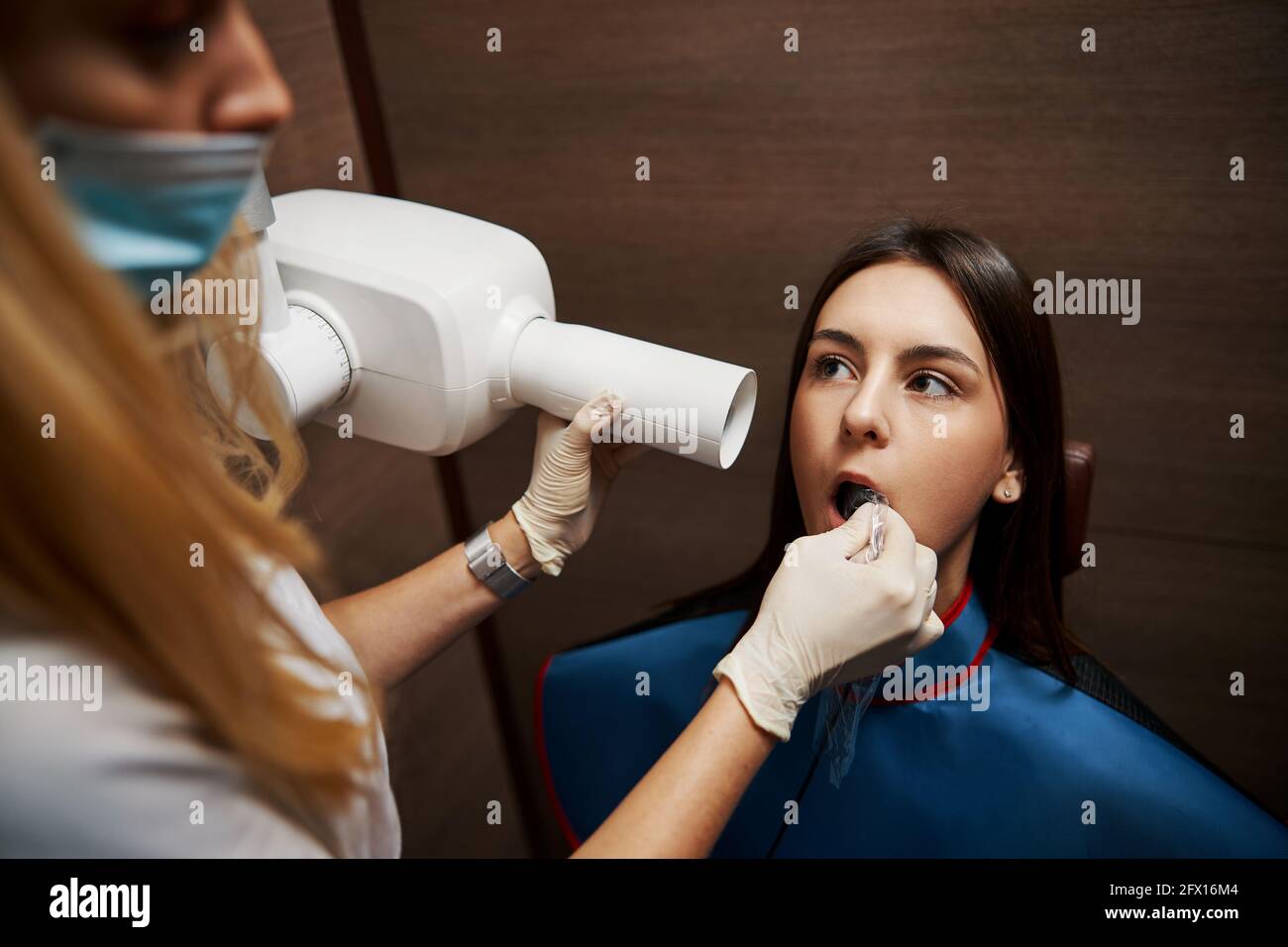 Xray film placed in woman mouth during teeth inspection Stock Photo