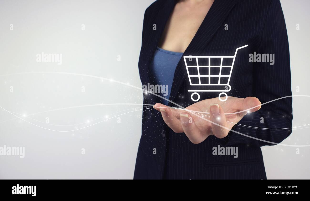 Online E-Commerce Shopping concept. Hand hold digital hologram Shopping cart on grey background. Digital Marketing Online, e-commerce add to cart onli Stock Photo