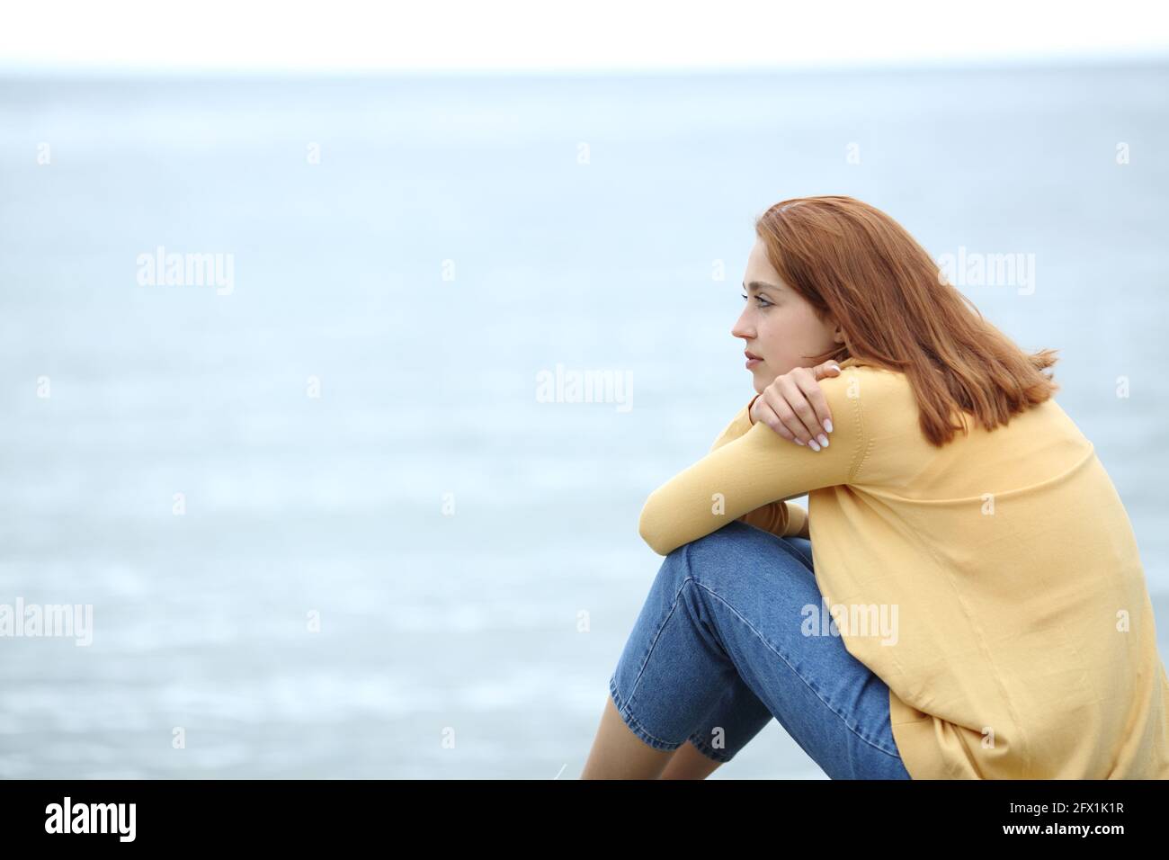 Serious pensive woman contemplating on the beach Stock Photo