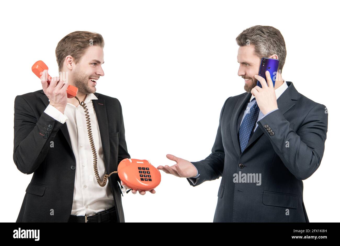 Happy business professionals use classic telephone and cell phone ...