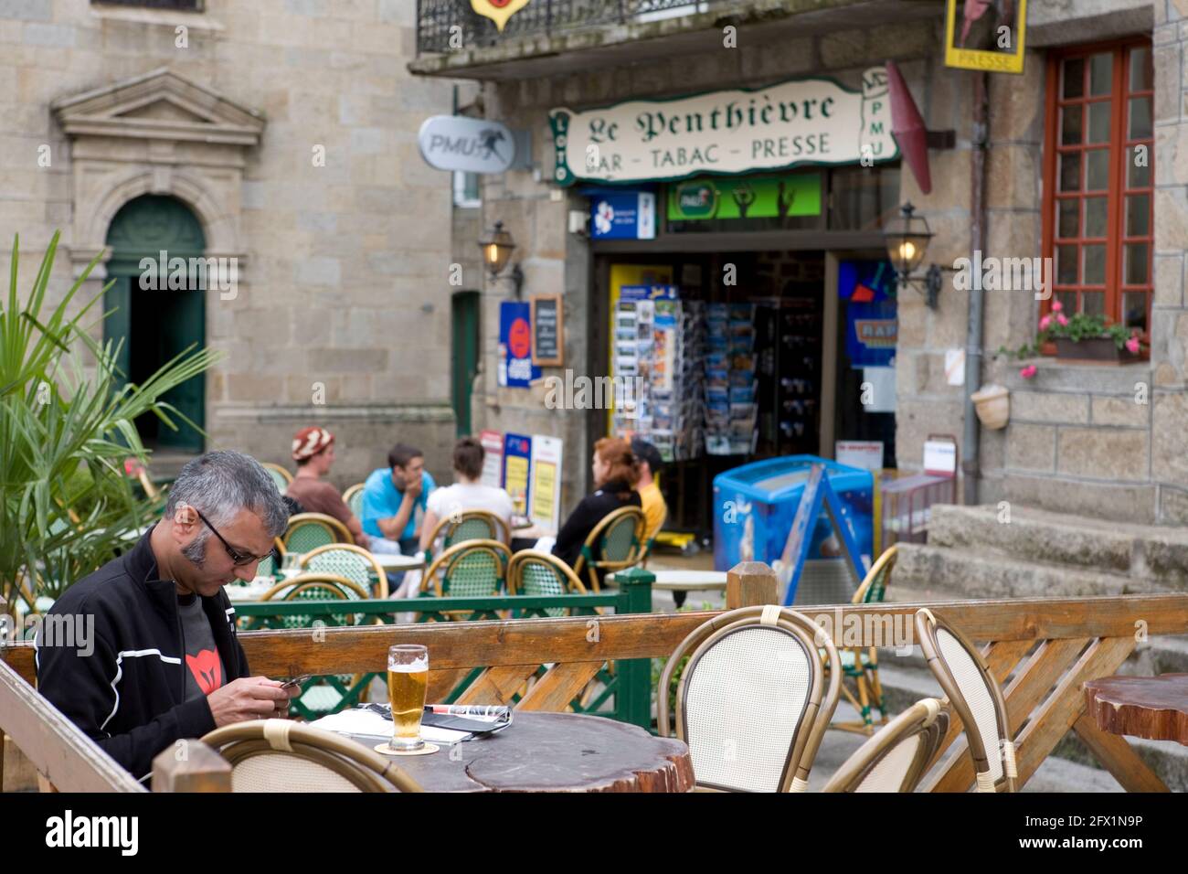 Relaxing al fresco: a bar on Place de Penthièvre, Moncontour, Côtes d'Armor, Brittany, France Stock Photo