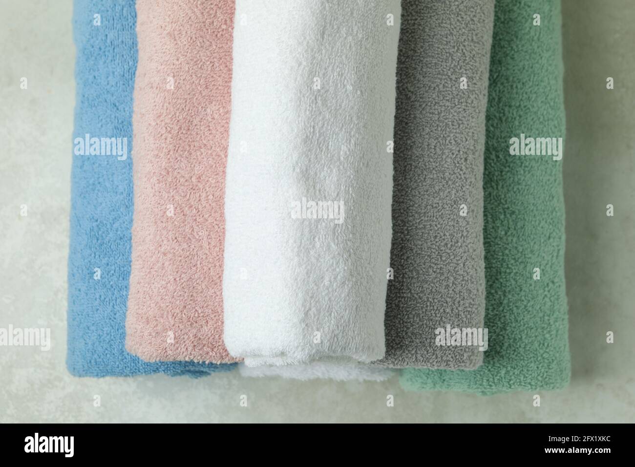 Clean rolled towels on textured background, top view Stock Photo