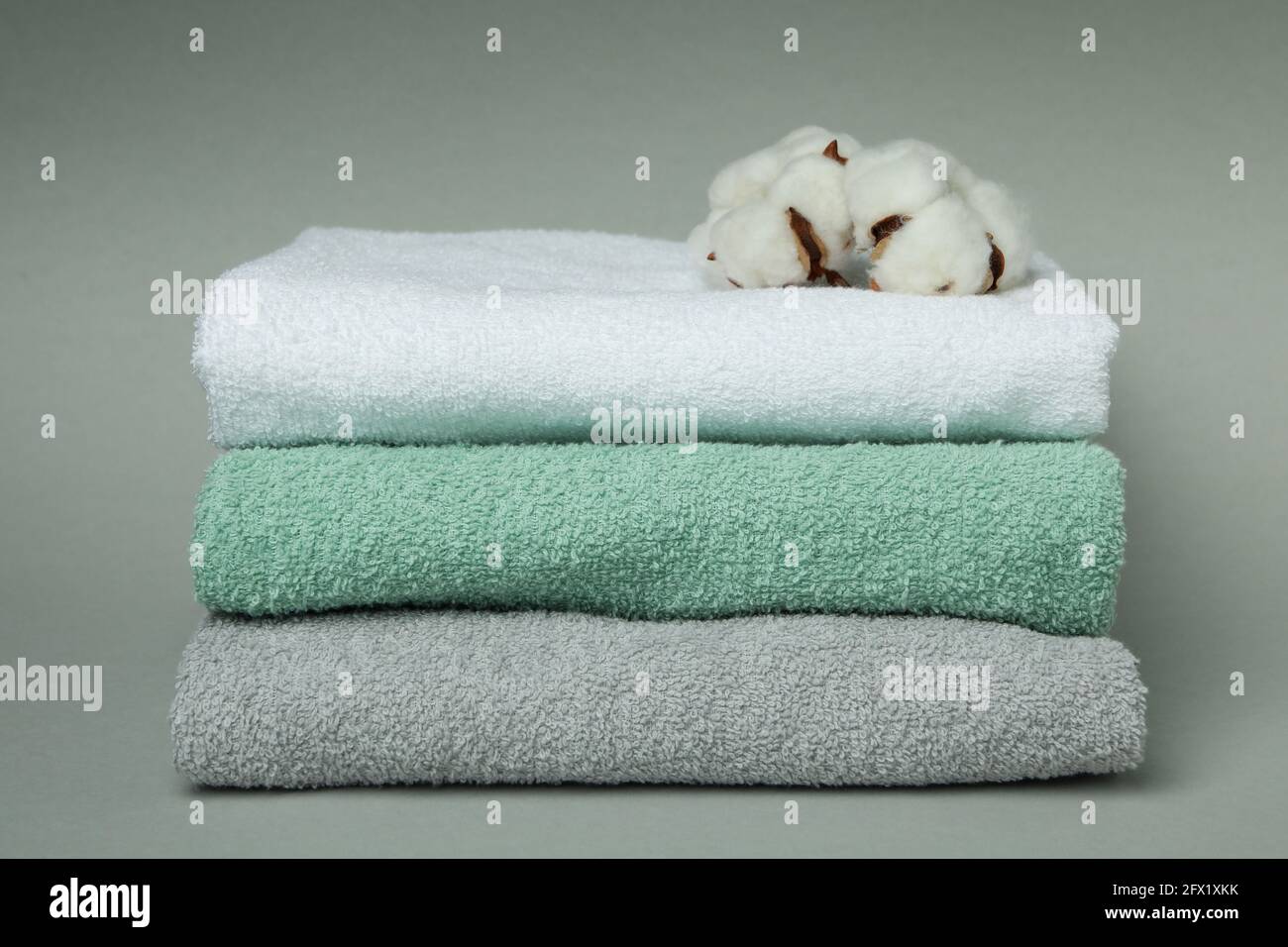 Clean folded towels with cotton on gray background Stock Photo