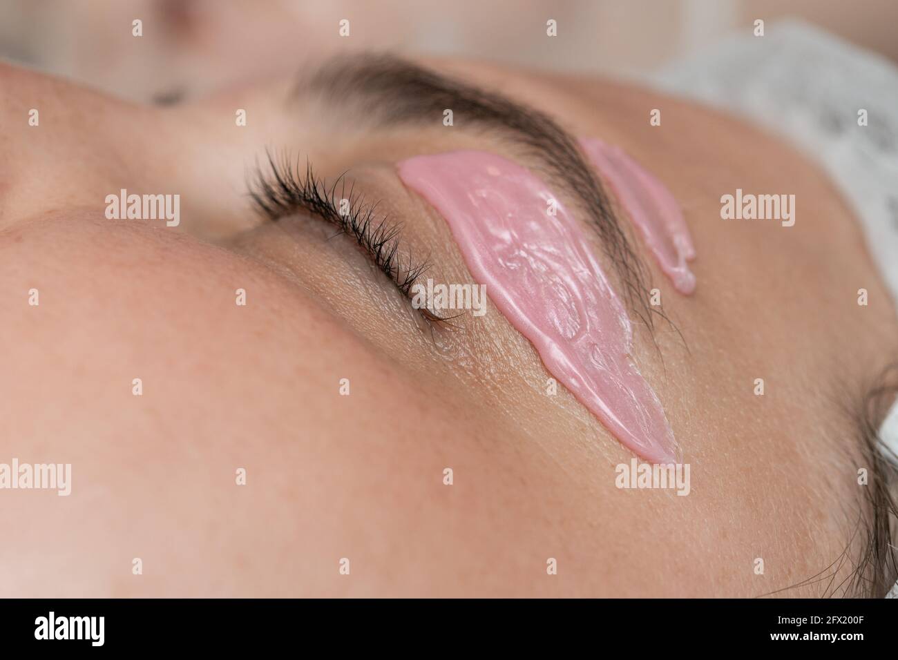 Hand of cosmetologist applying wax paste on armpit. Stock Photo