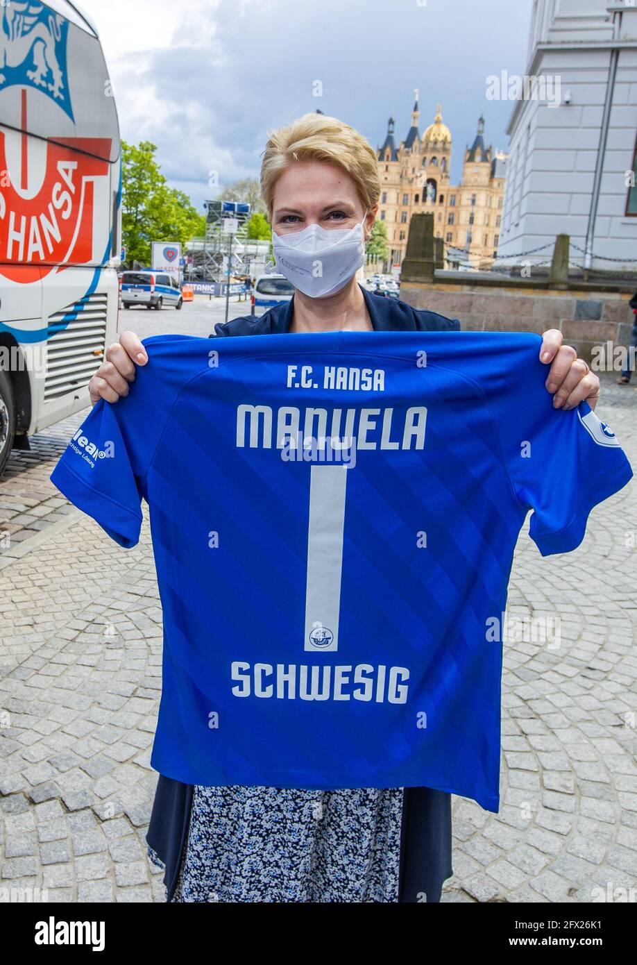 Schwerin, Germany. 25th May, 2021. Manuela Schwesig (SPD), Prime Minister  of Mecklenburg-Western Pomerania, holds a jersey of the football club FC  Hansa Rostock with her name and the number 1 on the