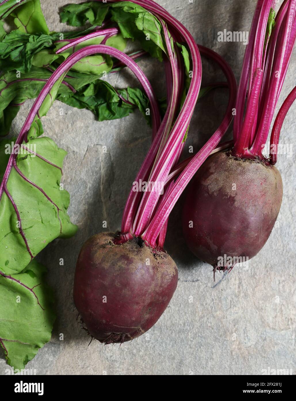 Red Beet Root With Leaves on stone table Stock Photo