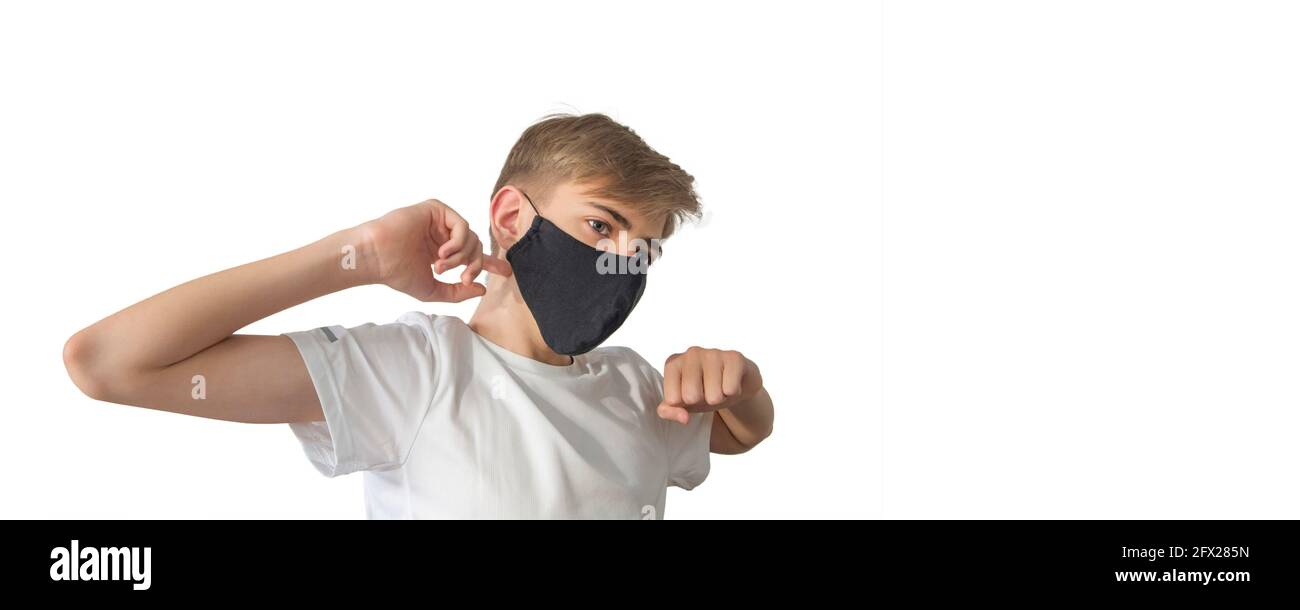 Portrait of a teenage boy in a surgical medical protective black mask on a white background, copy space Stock Photo