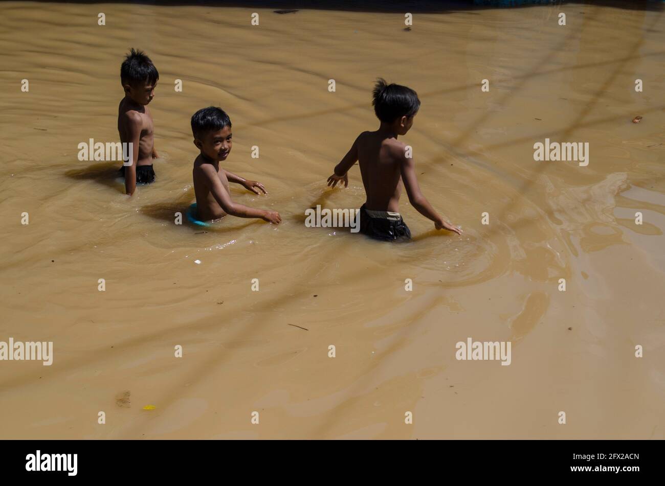 Bandung, Indonesia. 25th May, 2021. Children wade through floodwater due to the overflow of Citarum river, in Bandung, West Java, Indonesia, May 25, 2021. Credit: Septianjar/Xinhua/Alamy Live News Stock Photo