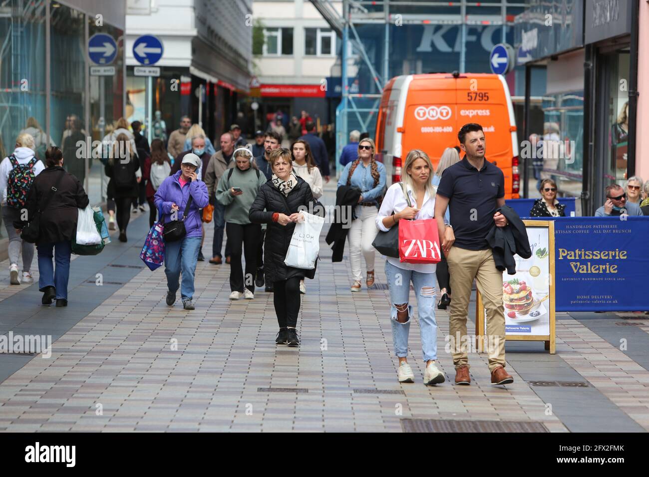 Belfast 25 May 2021.  Shoppers rteurn to Belfast City Centre as shops and business reopen from Covid  lockdown. People in Northern Ireland are now able to enjoy a drink or bite to eat inside pubs and restaurants, as hospitality opens fully for the first time since December. Six people from any number of households can sit together or up to 10 people provided they are all from the same household. The easing of coronavirus restrictions also means six people from two households can now meet indoors in homes. Credit: Paul McErlane/Alamy Live News Stock Photo