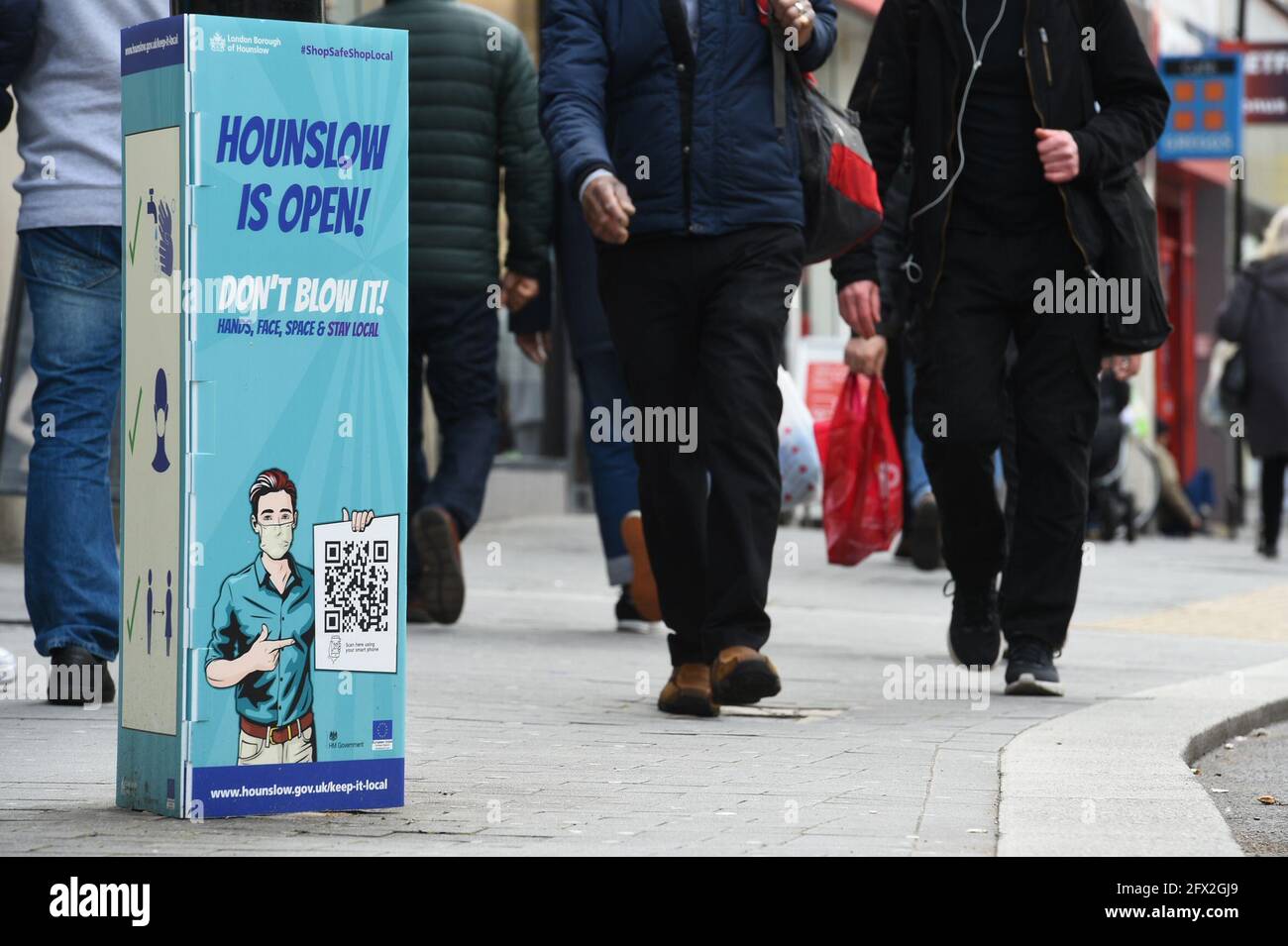 A Covid-19 sign on the high street in Hounslow, west London, one of the areas of the UK where the Covid variant first identified in India is spreading fastest. Picture date: Tuesday May 25, 2021. Stock Photo