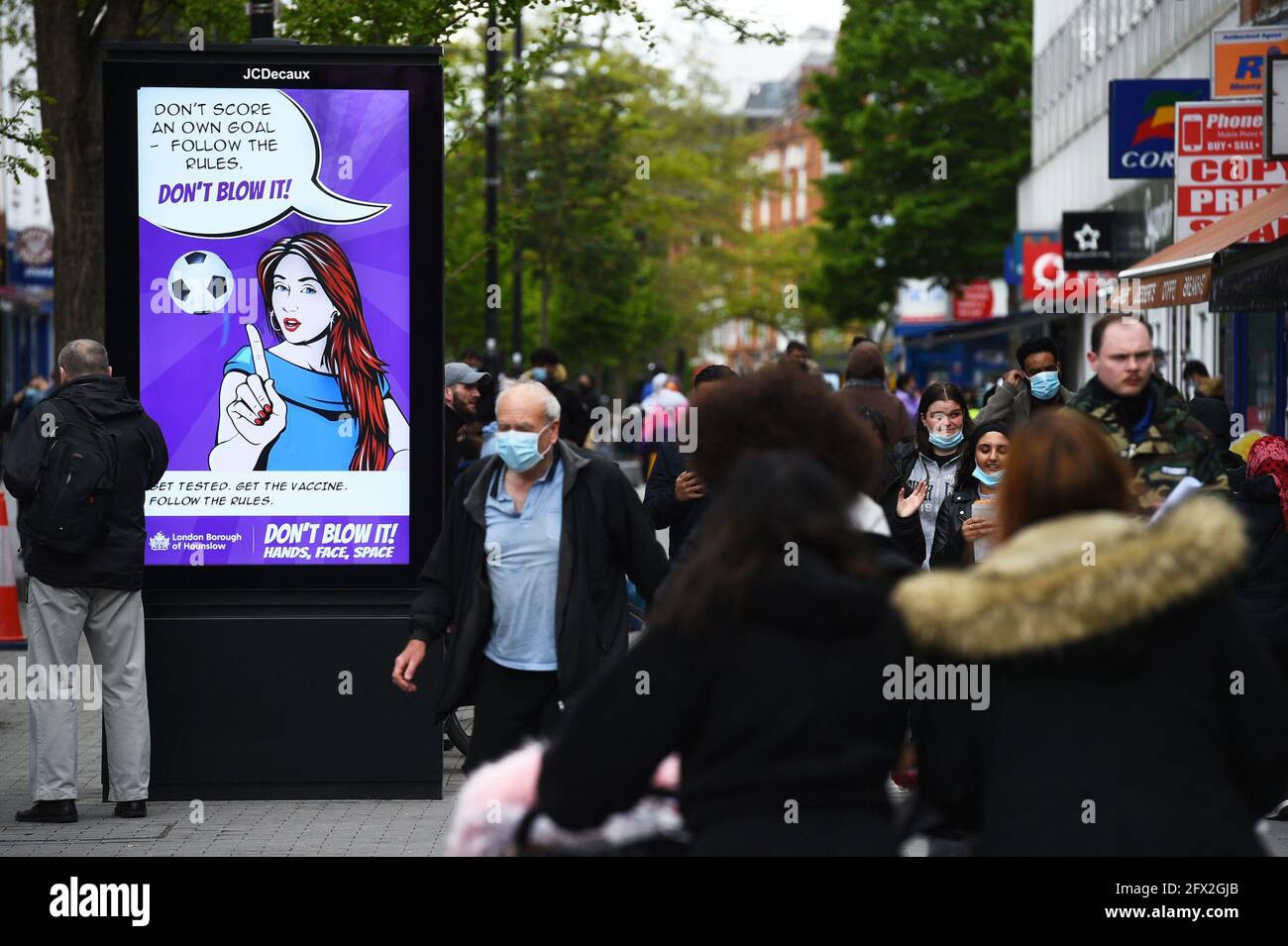 A Covid-19 sign on the high street in Hounslow, west London, one of the areas of the UK where the Covid variant first identified in India is spreading fastest. Picture date: Tuesday May 25, 2021. Stock Photo