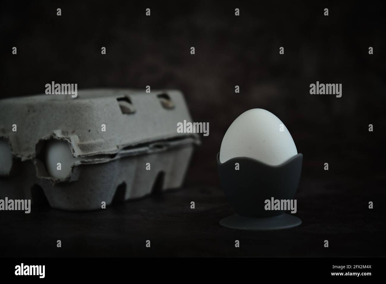 white egg on a stand on a dark background Stock Photo