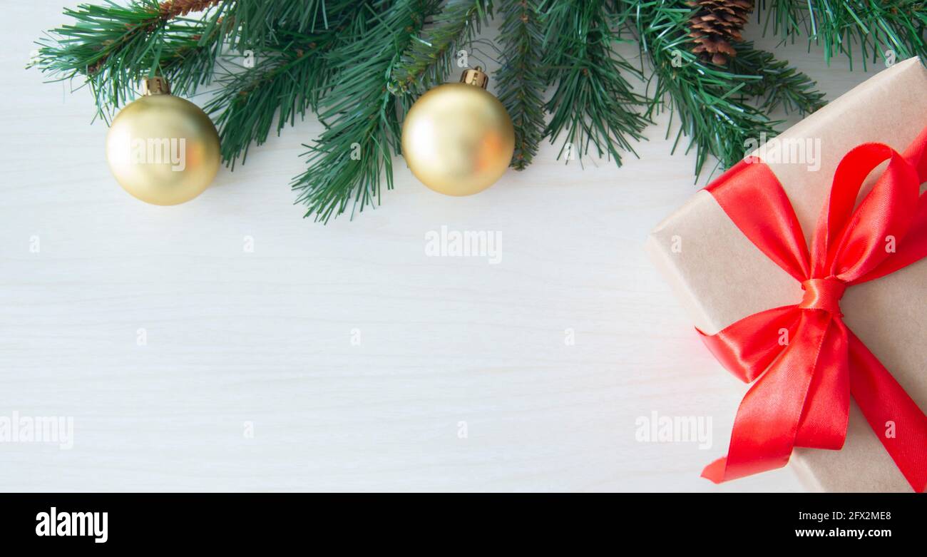 Decorated fir branch on tree with Gift box on wood background. Space for text Stock Photo