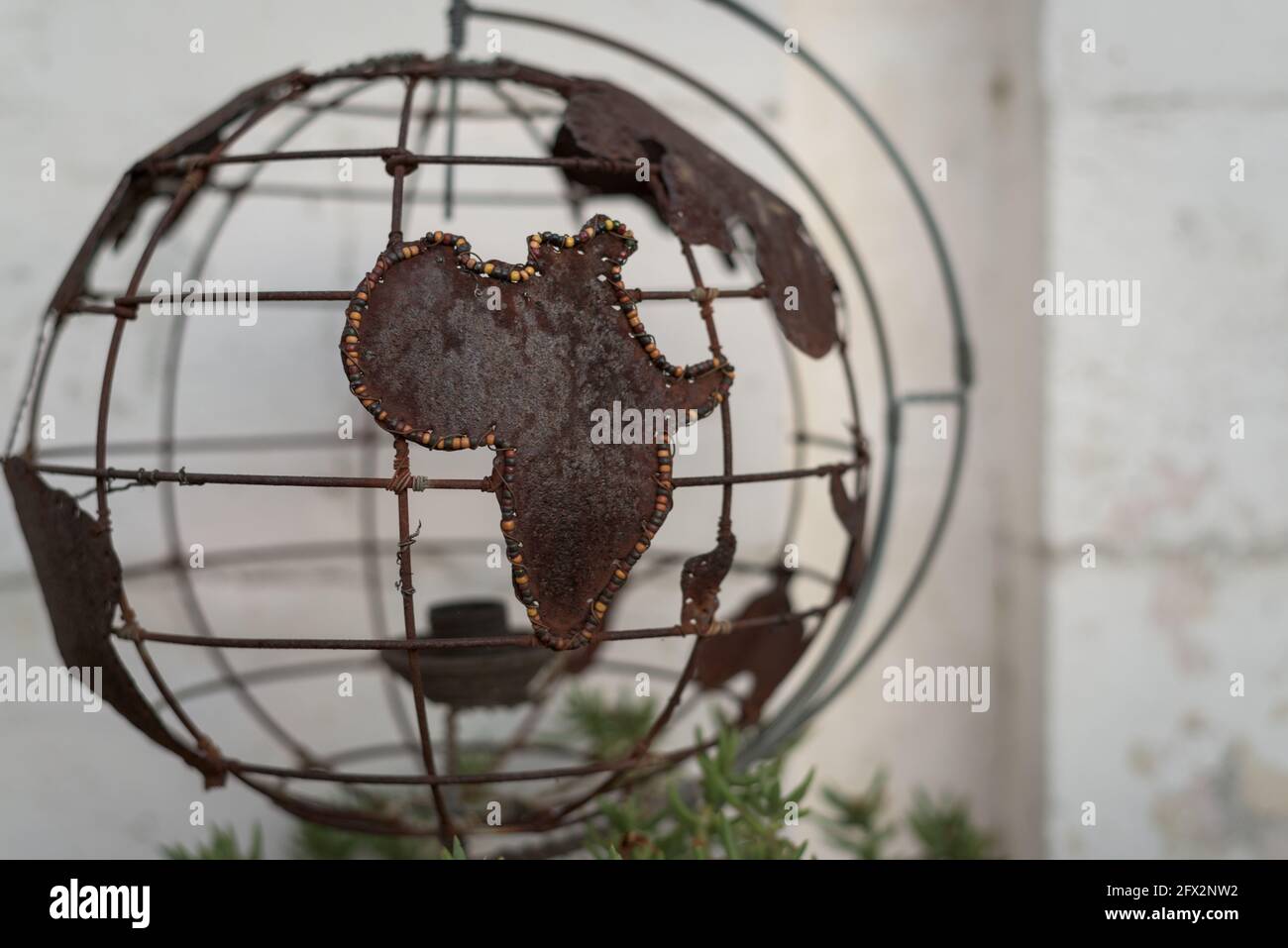 A wire workers globe and the beaded outline of the African continent Stock Photo