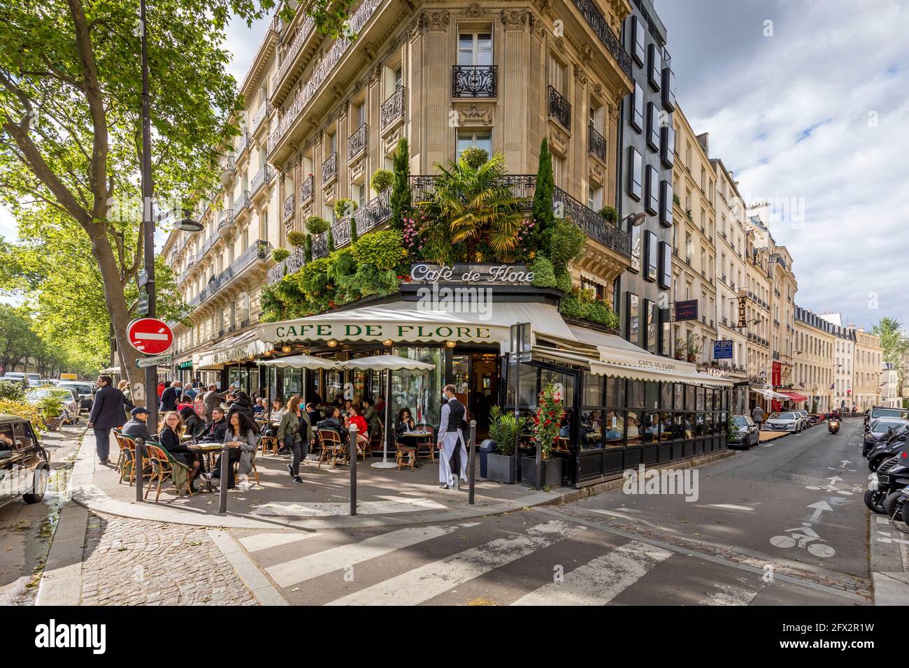 Paris, France - May 19, 2021: Day after lockdown due to covid-19 in a famous Parisian cafe. 2 waiters wear surgical masks Stock Photo