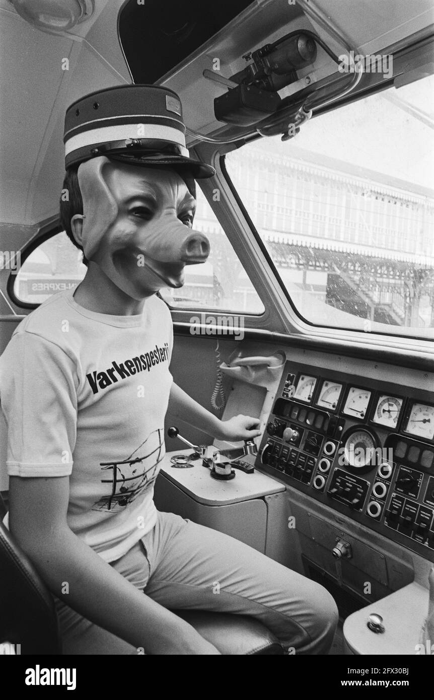 Employee of the Lekker Dier foundation with a mask of a pig's head and action shirt in the driver's cab, August 19, 1983, actions, bio-industry, animal protection, masks, trains, pigs, The Netherlands, 20th century press agency photo, news to remember, documentary, historic photography 1945-1990, visual stories, human history of the Twentieth Century, capturing moments in time Stock Photo