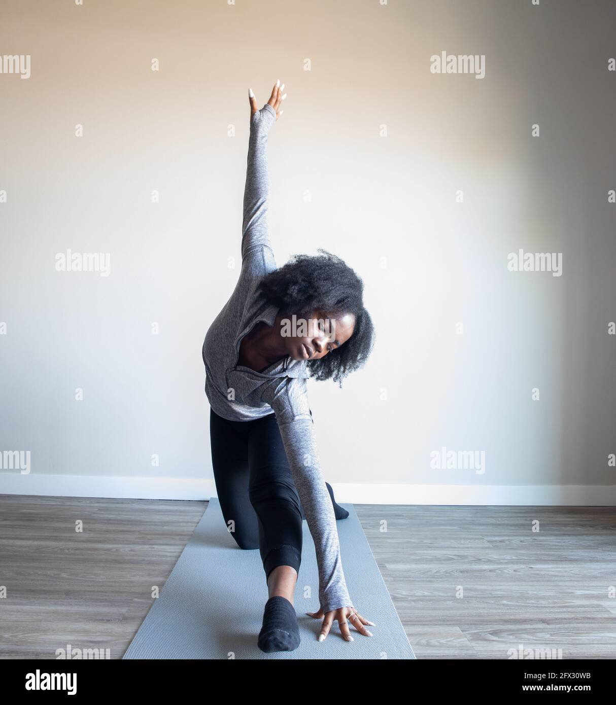 Young woman doing yoga pose on mat. one person, african american, black woman, close up, natural hair Stock Photo