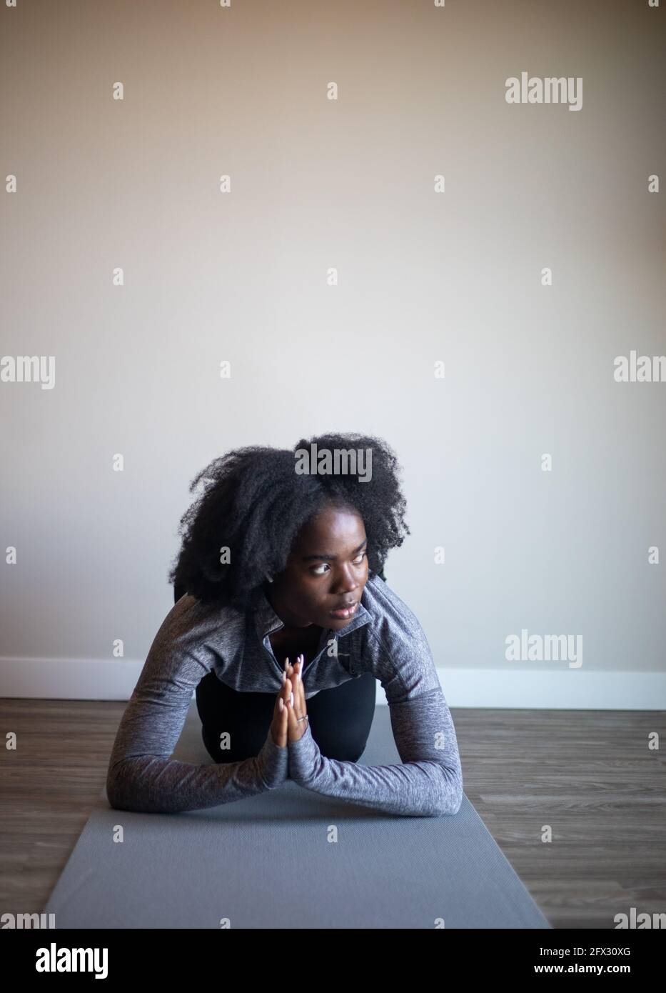 Young attractive woman practicing yoga, working out, wearing sportswear, indoor, natural hair, black woman, african american, pants and top, Stock Photo