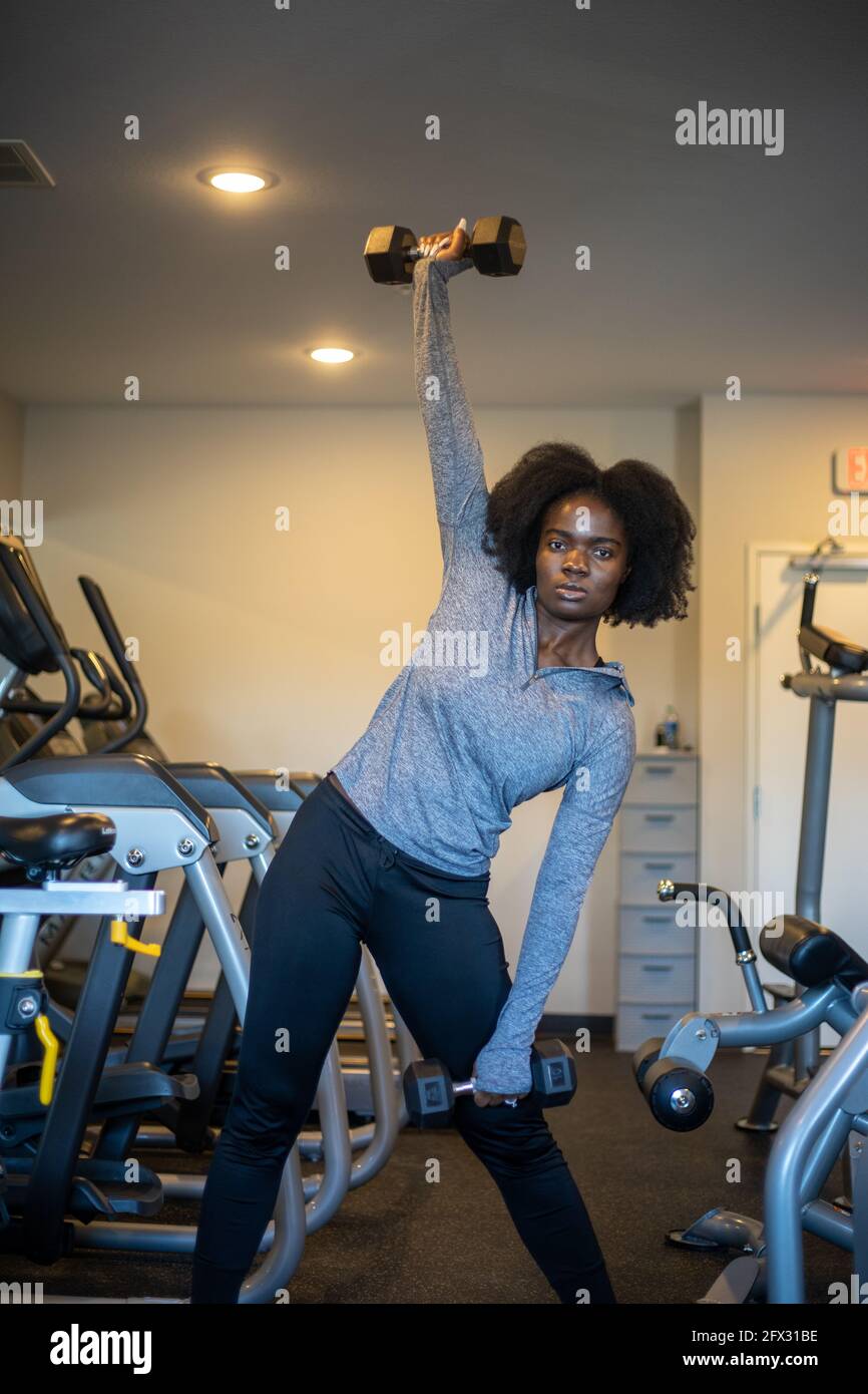 woman lift dumbbells at home gym. close up, one person, fitness model, African American, African model, sportswear, natural hair model, background, bl Stock Photo