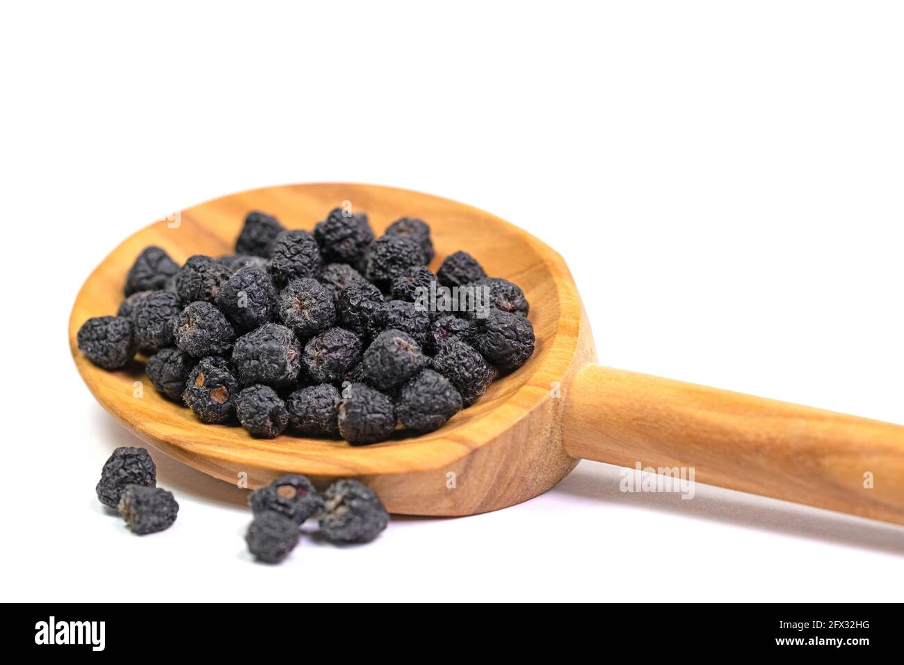 Dried Aronia berries, Aronia melanocarpa, on a wooden spoon Stock Photo