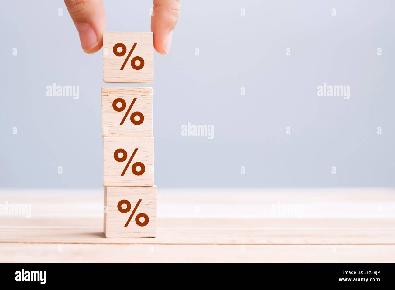 business man Hand putting wood cube block with percentage symbol icon. Interest rate,  financial, ranking and mortgage rates concept Stock Photo