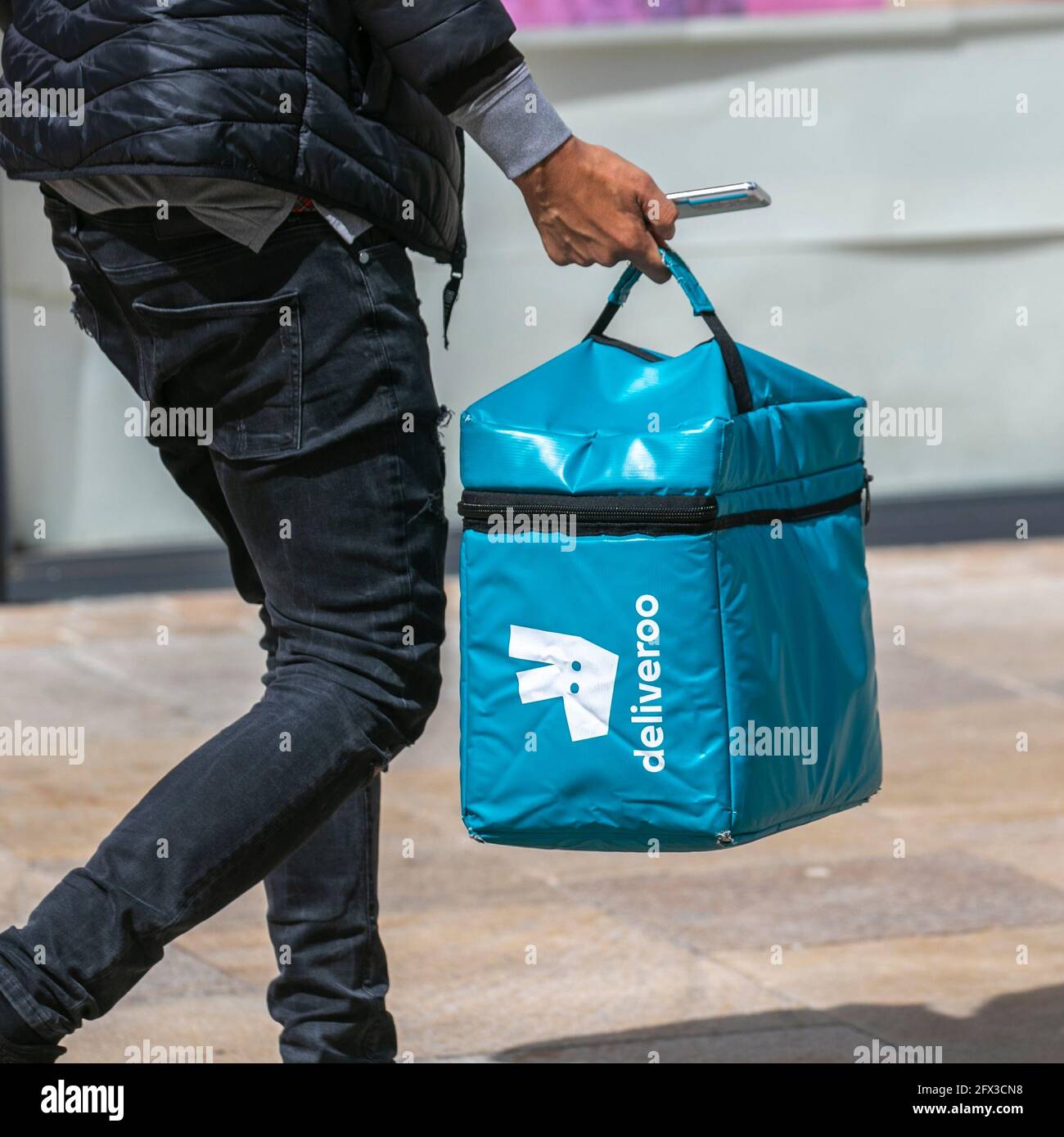 Deliveroo Hot food lunches on-line order being collected in Preston city-centre, UK Stock Photo