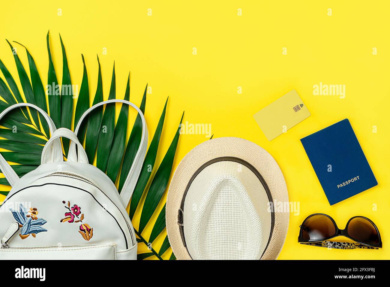 Summer flat lay of female travel accessories on yellow background. Directly above, copy space. Stock Photo