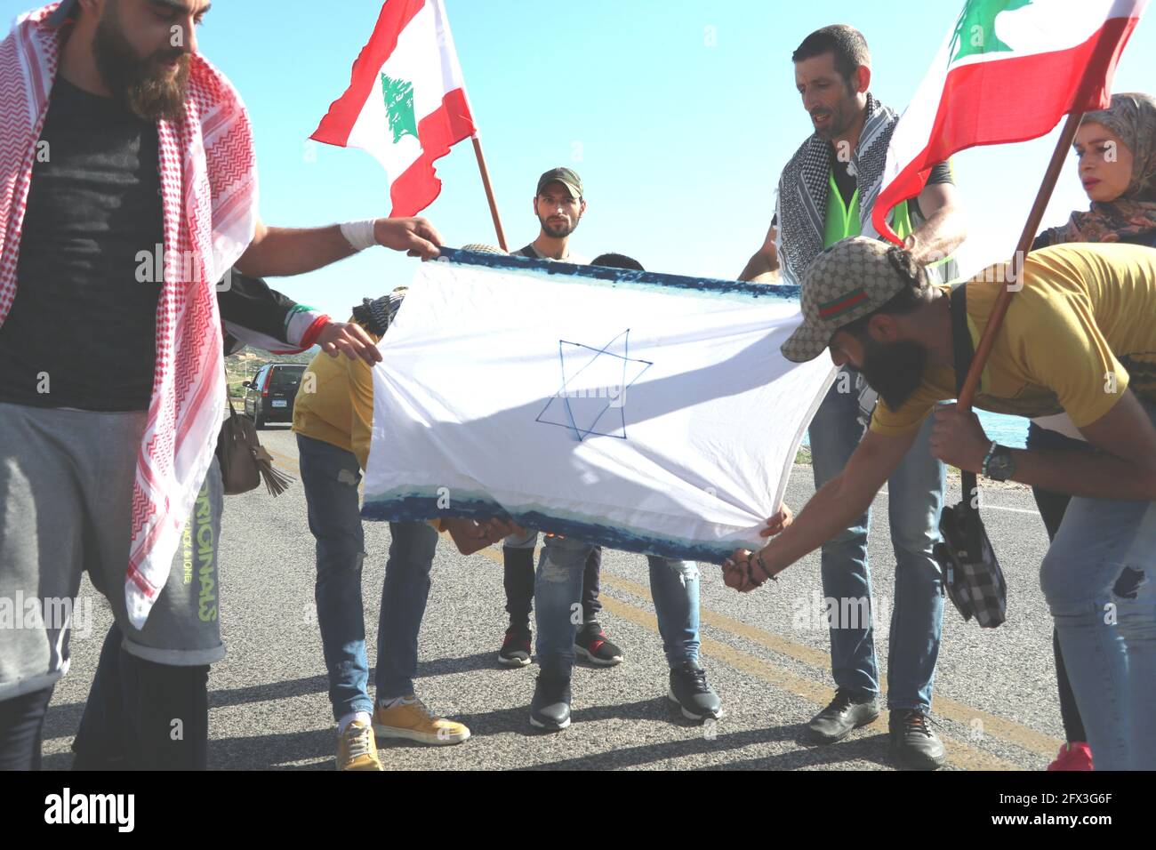 Lebanese and Palestinian activists burn Israeli flag on the border