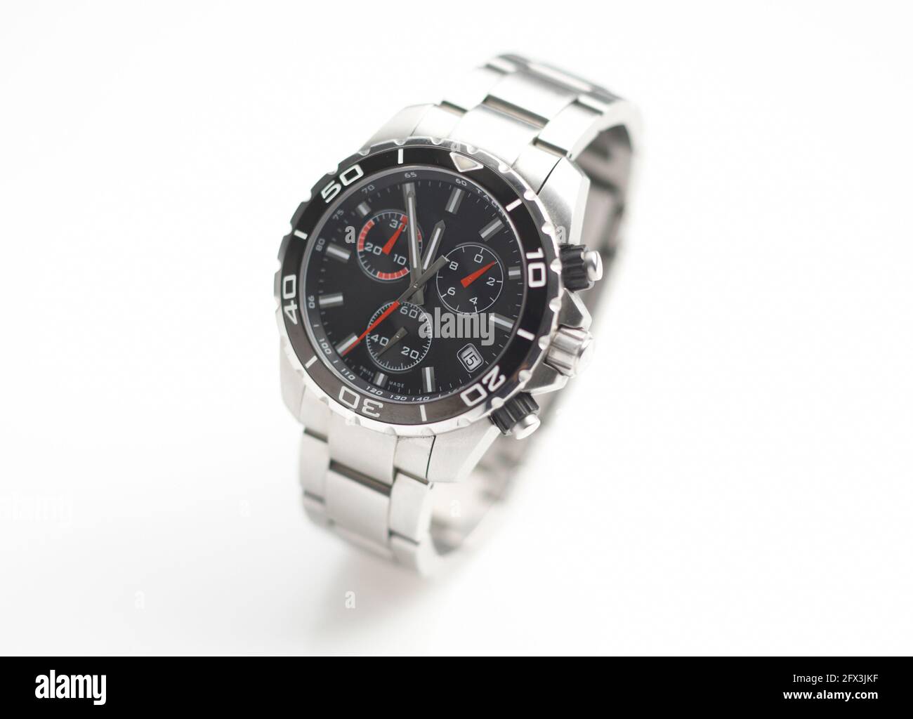 Chrome Wristwatch on white background showing five minutes to twelve Stock Photo