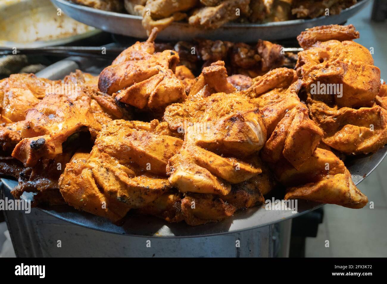 Spicy roasted tandoori butter chicken , prepared for sale at evening as street food in Old Delhi