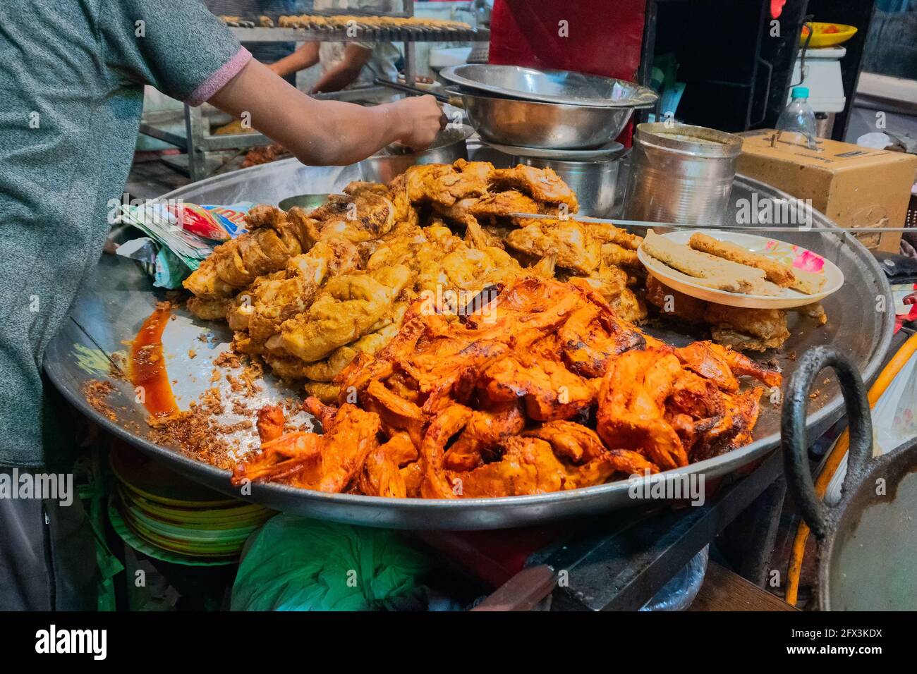 Spicy roasted tandoori butter chicken , prepared for sale at evening as street food in Old Delhi