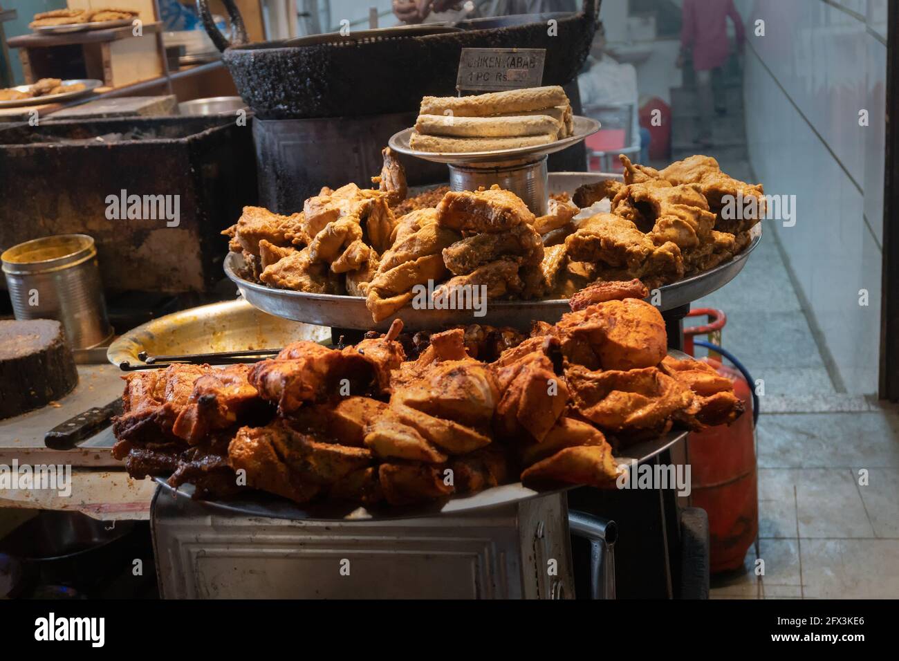 Spicy roasted tandoori butter chicken , prepared for sale at evening as street food in Old Delhi market. It is famous for spicy Indian non vegetarian Stock Photo